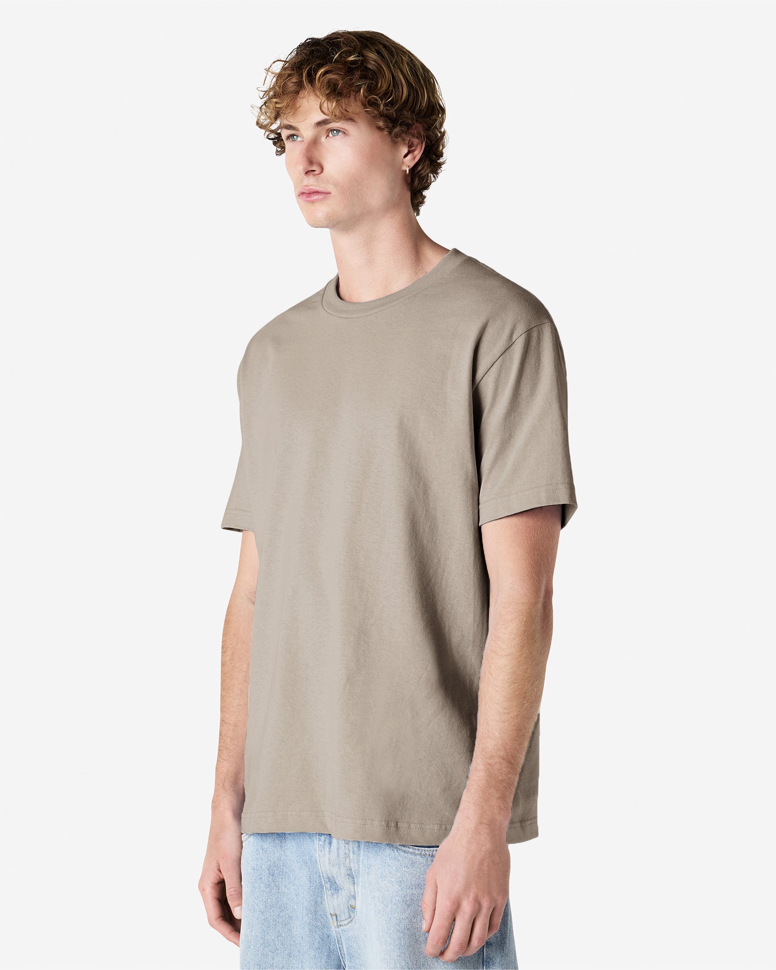 Male Model wearing a Slate Heavyweight Unisex Short Sleeve Crew Neck Tee, paired with blue jeans, standing against a plain background (front pose) -Slate