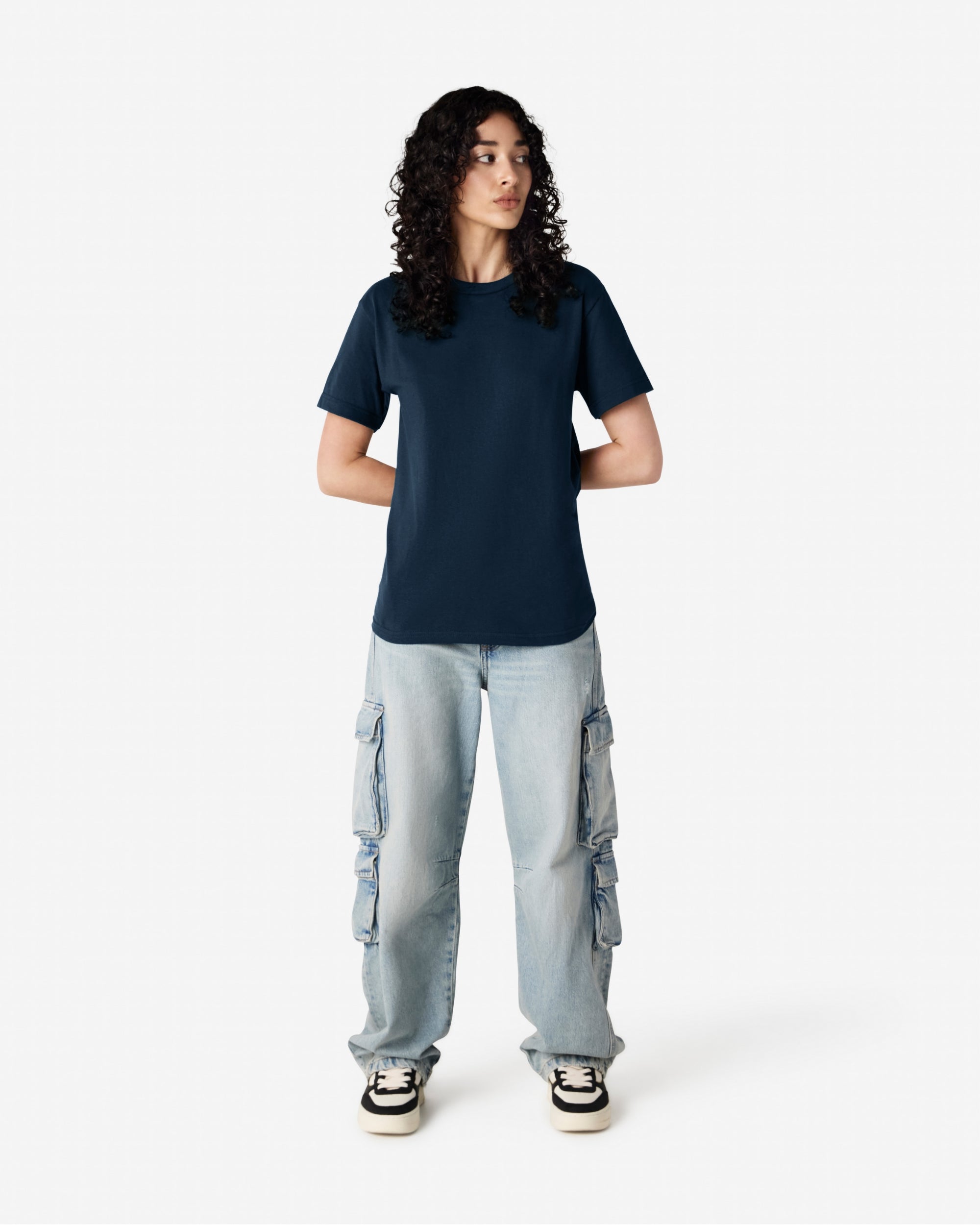 Female Model wearing a True Navy Heavyweight Unisex Short Sleeve Crew Neck Tee, paired with blue jeans, standing against a plain background (front pose) -true navy