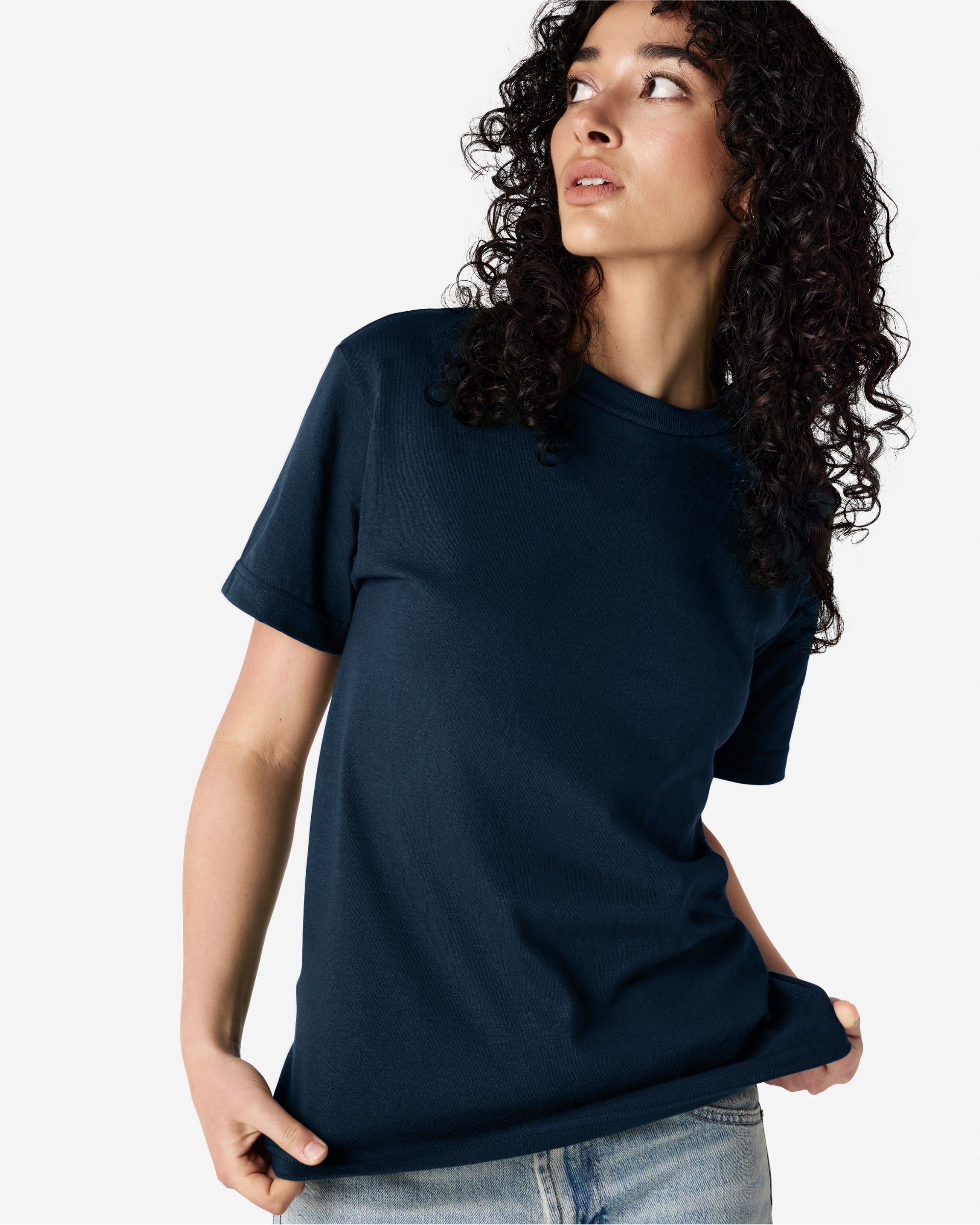 Female Model wearing a True Navy Heavyweight Unisex Short Sleeve Crew Neck Tee, paired with blue jeans, standing against a plain background (front pose) -true navy