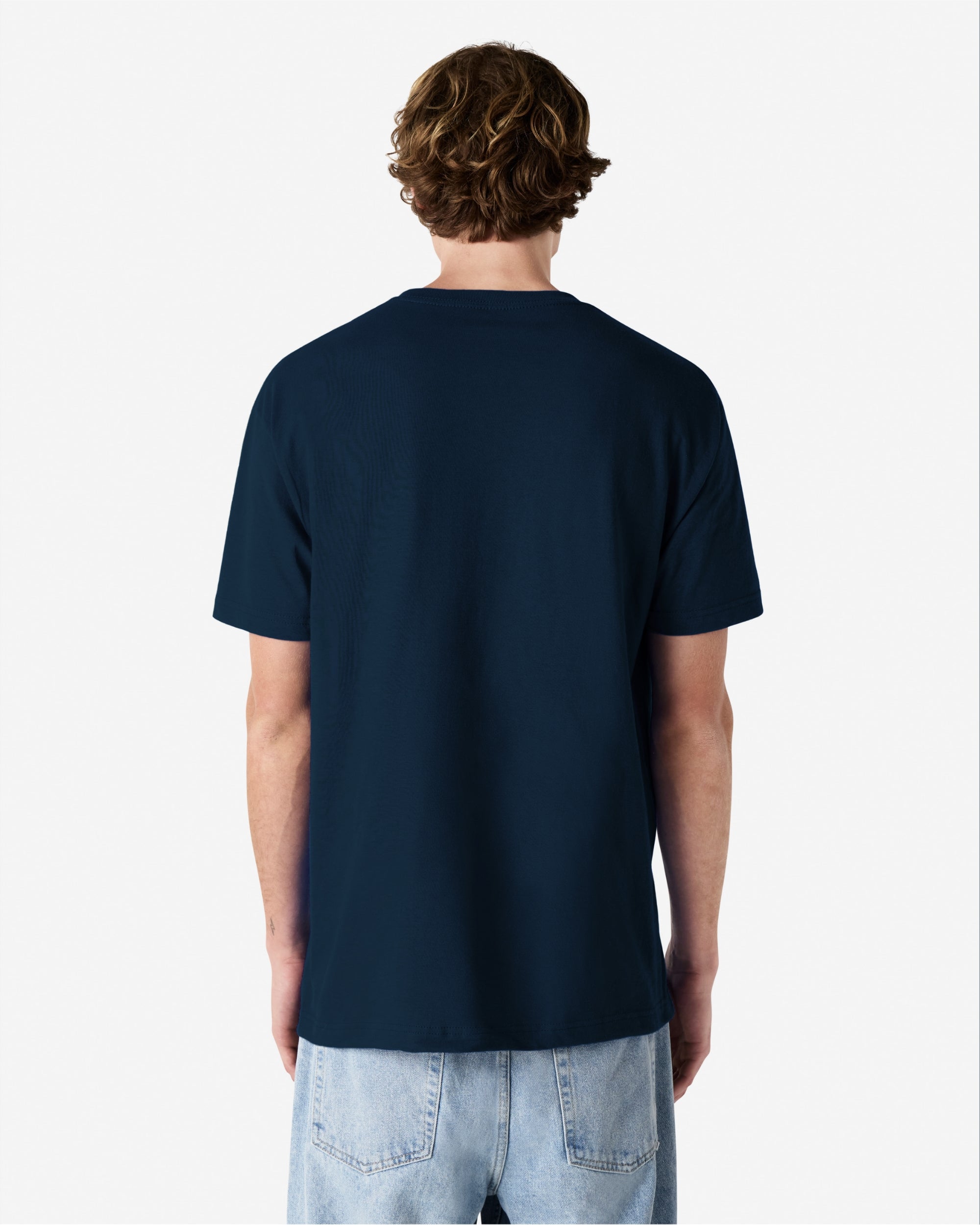 Male Model wearing a True Navy Heavyweight Unisex Short Sleeve Crew Neck Tee, paired with blue jeans, standing against a plain background (back pose) -true navy