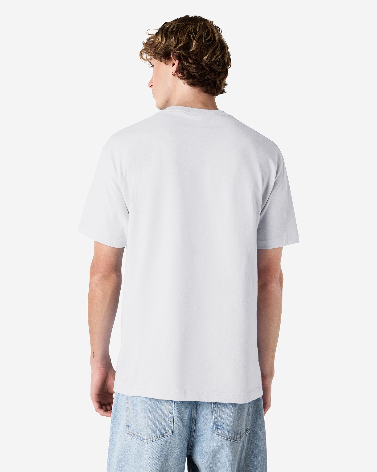 Male Model wearing a White Heavyweight Unisex Short Sleeve Crew Neck Tee, paired with blue jeans, standing against a plain background (back pose) -white