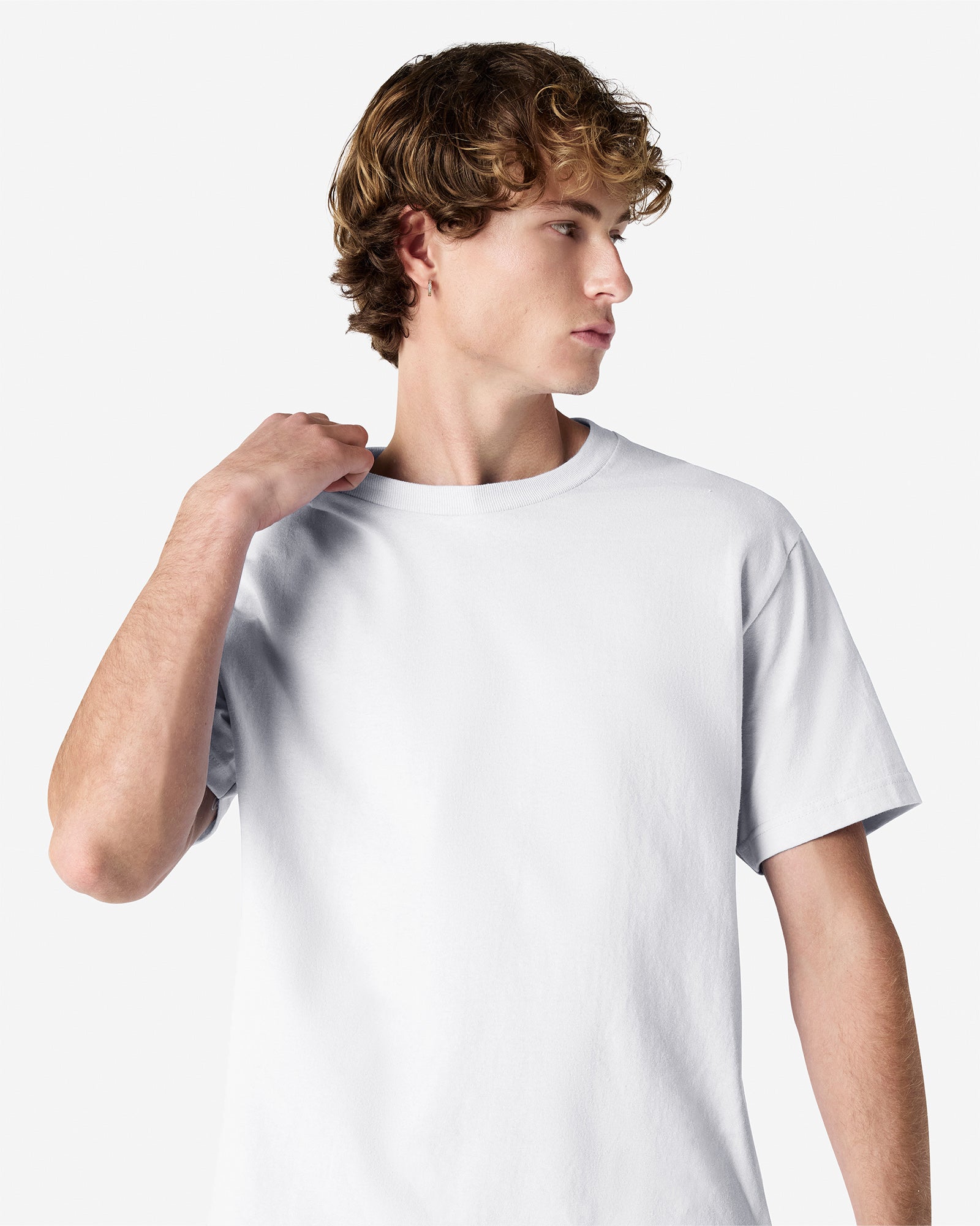 Male Model wearing a White Heavyweight Unisex Short Sleeve Crew Neck Tee, paired with blue jeans, standing against a plain background (front pose) -white