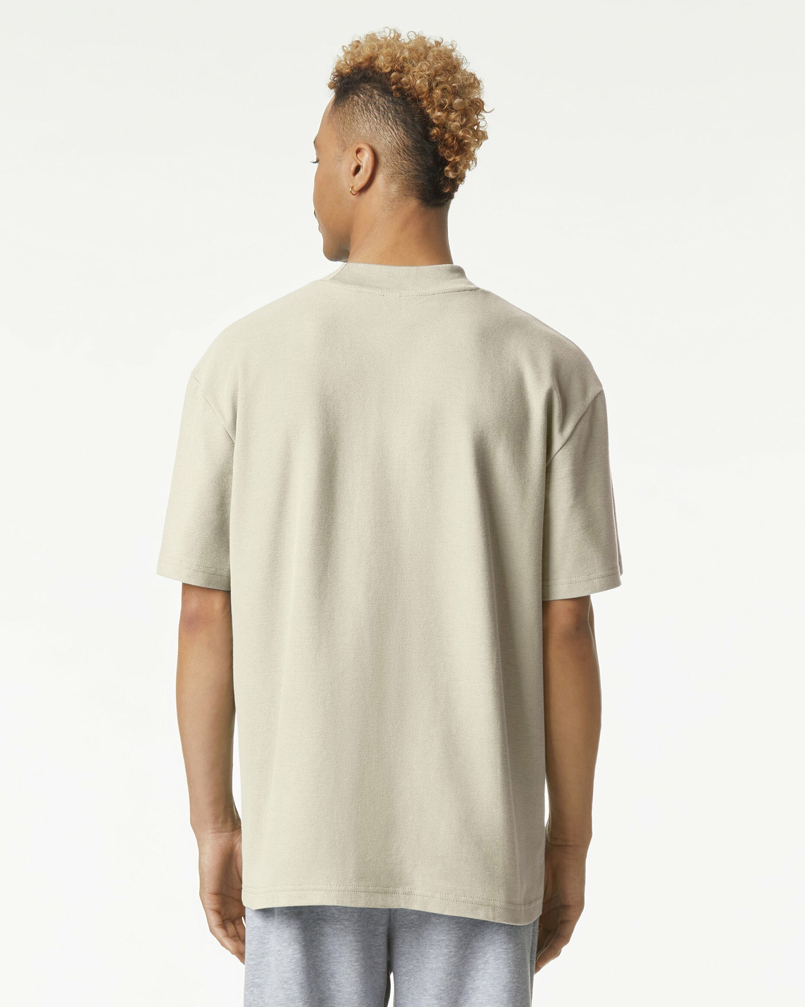 Male model wearing a Pique Unisex Mockneck Tee (back pose) -bone