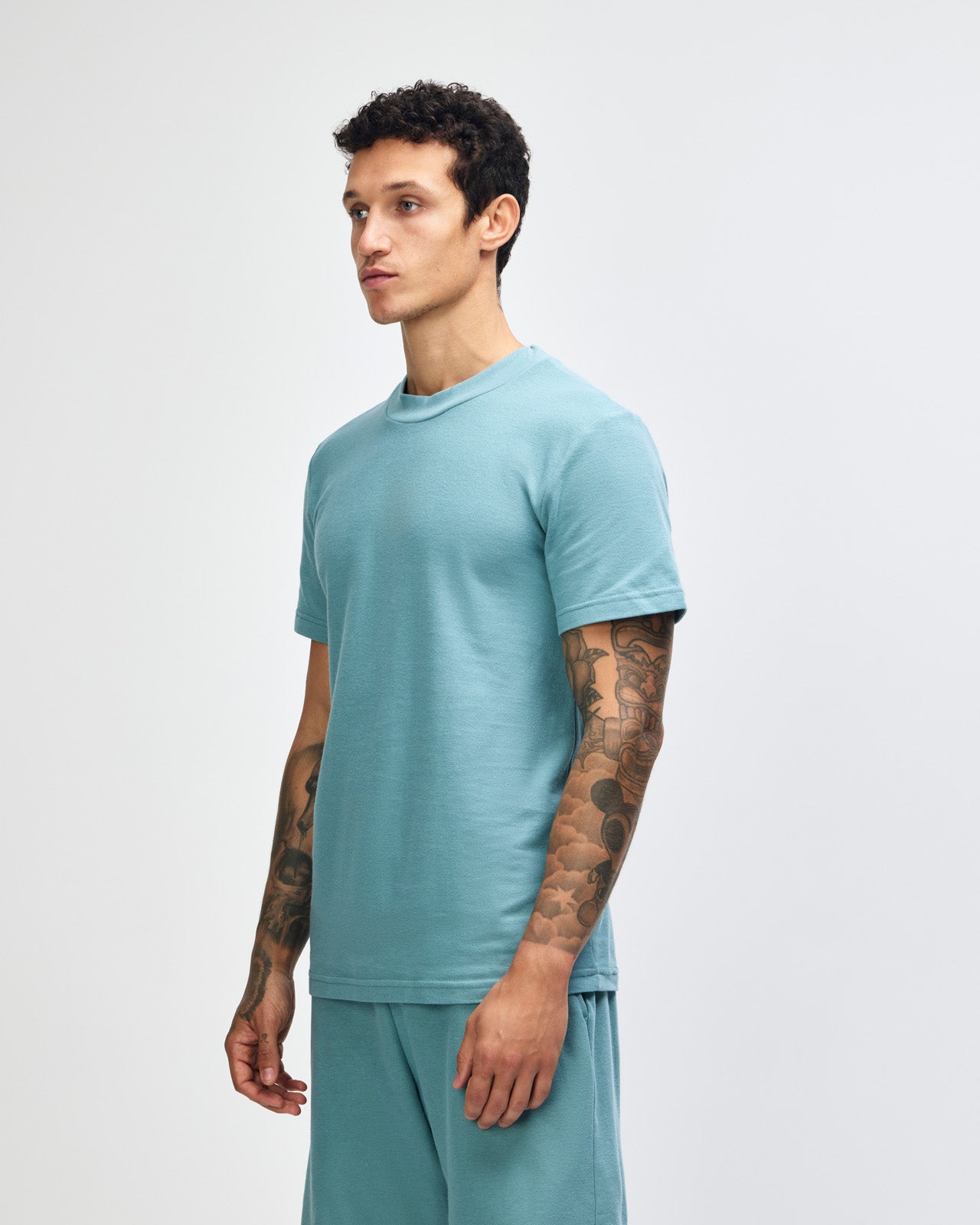 Male model wearing a Pique Unisex Mockneck Tee (front pose) -arctic