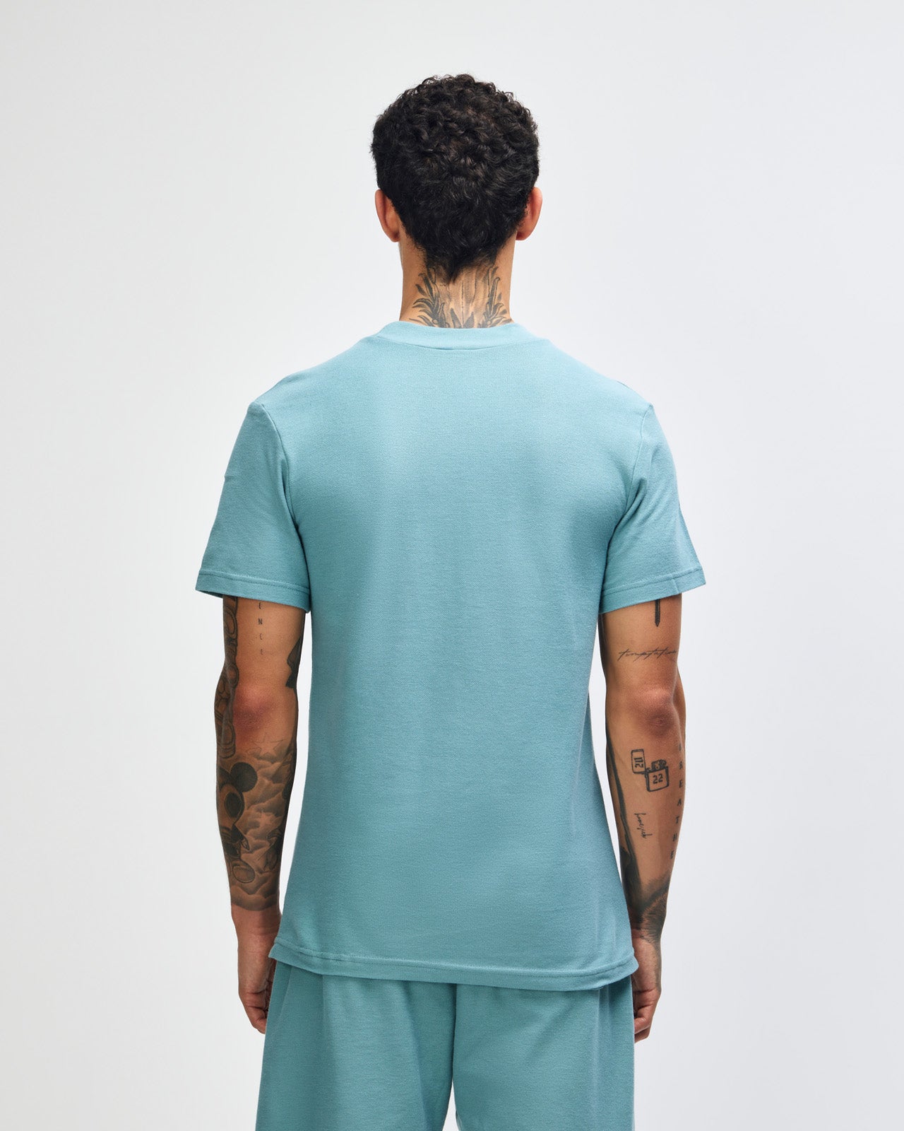 Male model wearing a Pique Unisex Mockneck Tee (front pose) -arctic