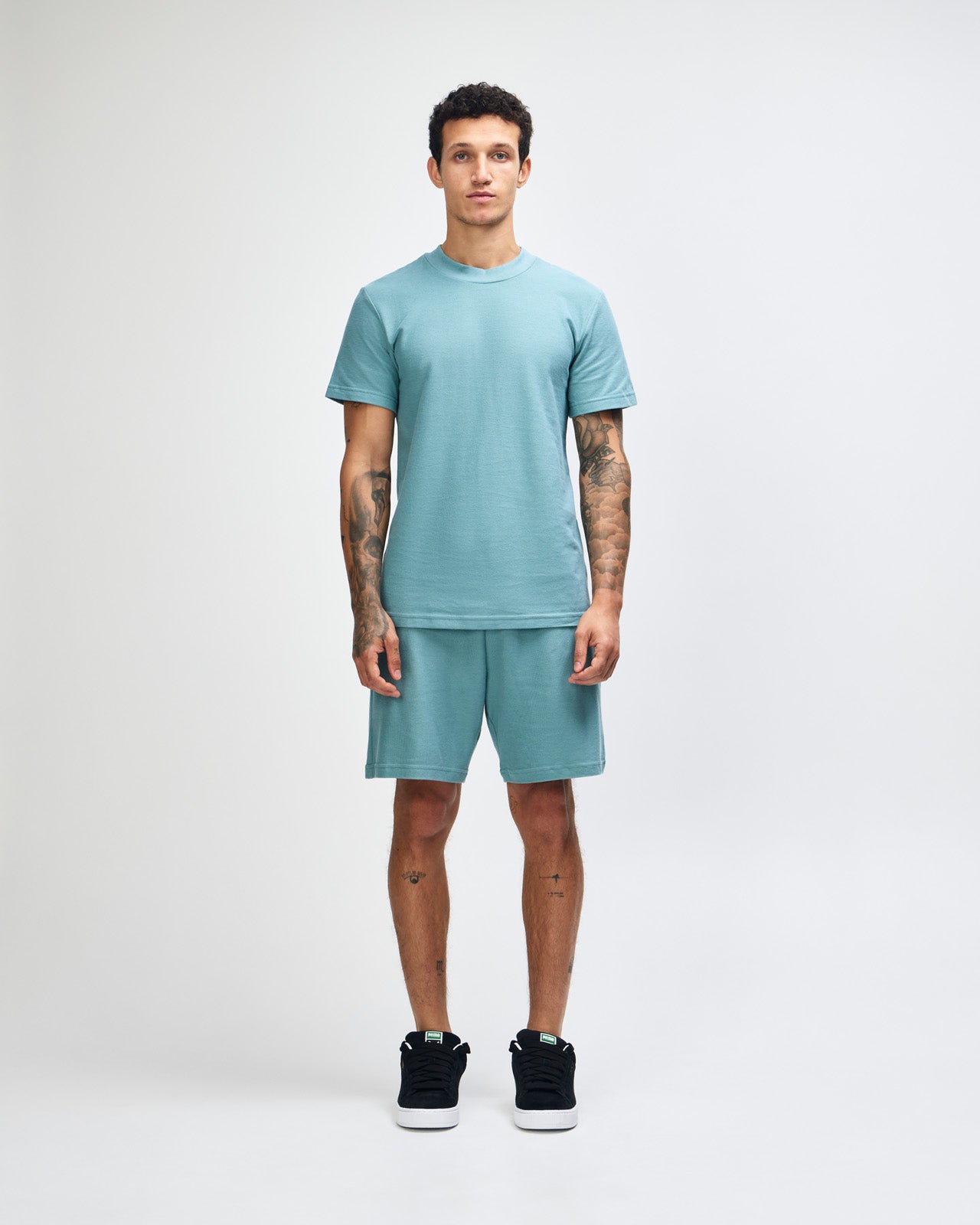 Male model wearing a Pique Unisex Mockneck Tee (front pose) -arctic