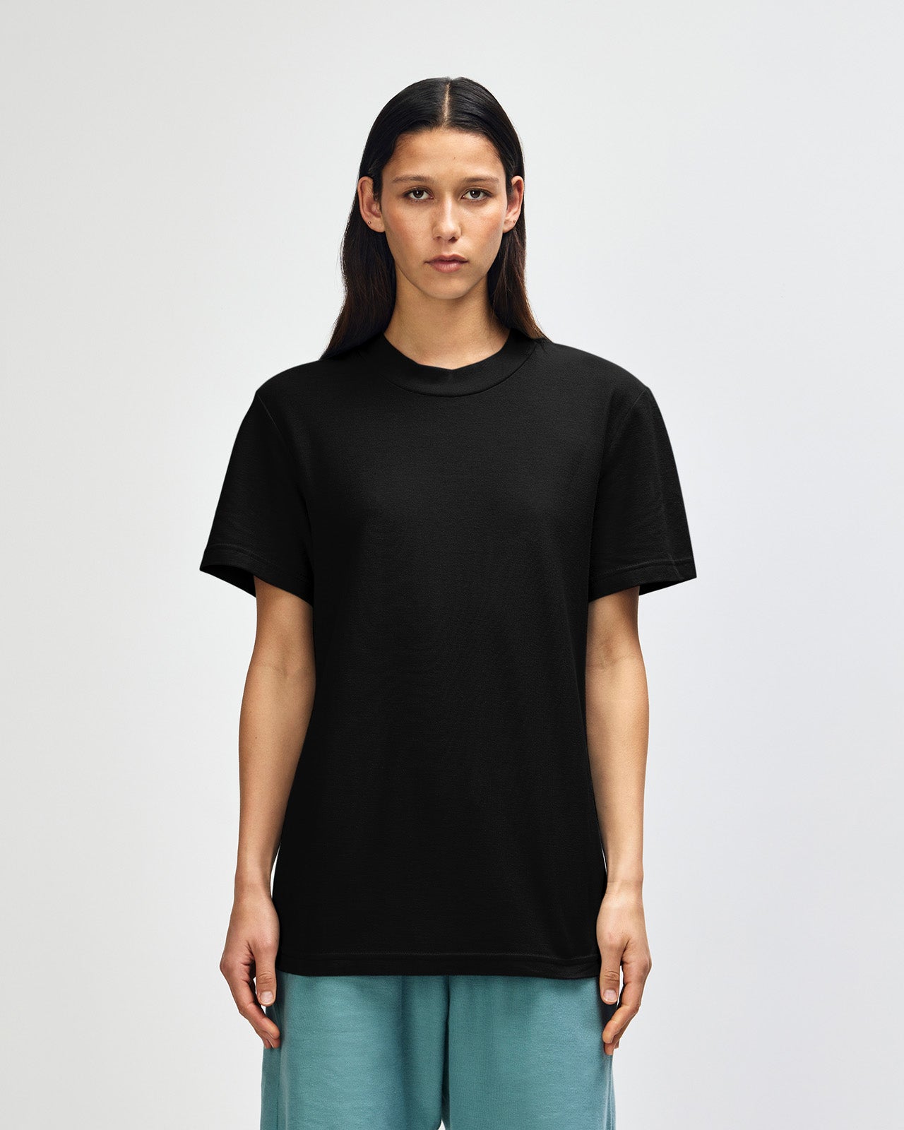 Female model wearing a Pique Unisex Mockneck Tee (front pose) -black