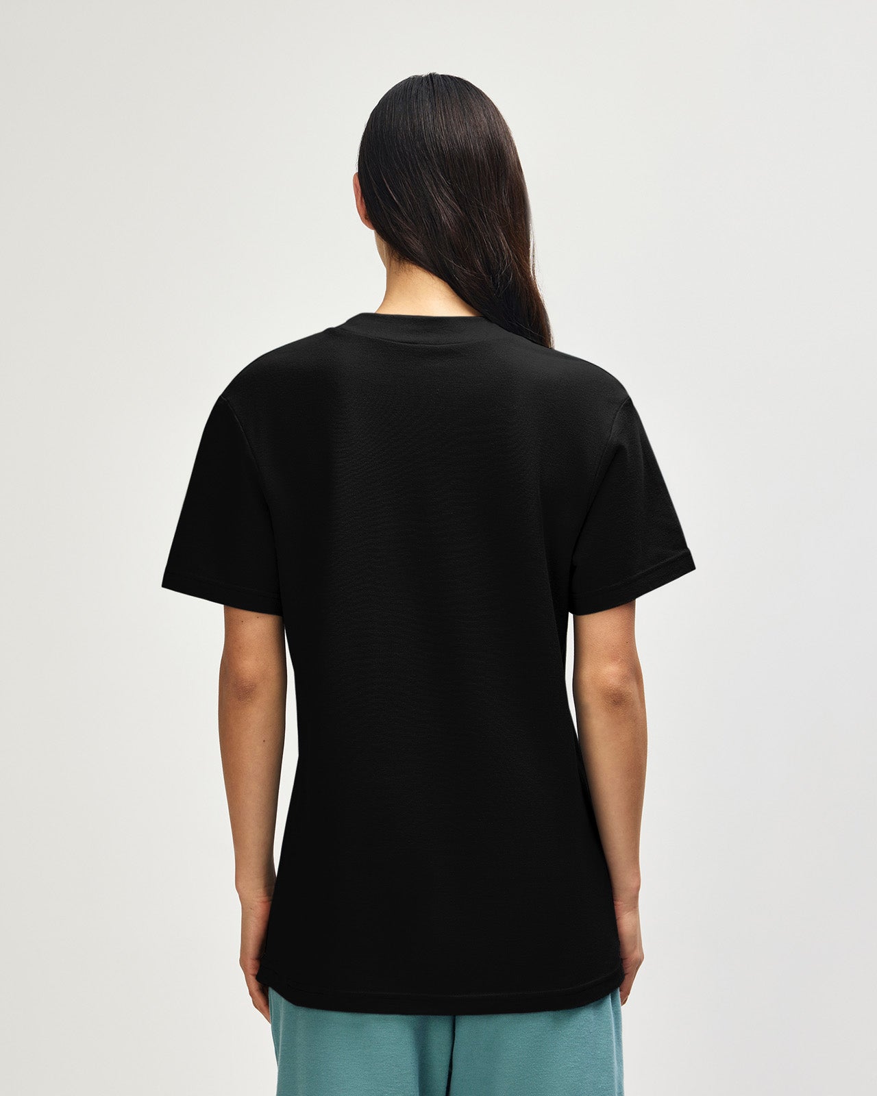 Female model wearing a Pique Unisex Mockneck Tee (front pose) -black