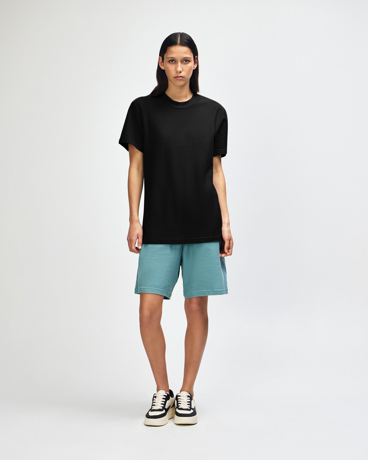 Female model wearing a Pique Unisex Mockneck Tee (front pose) -black