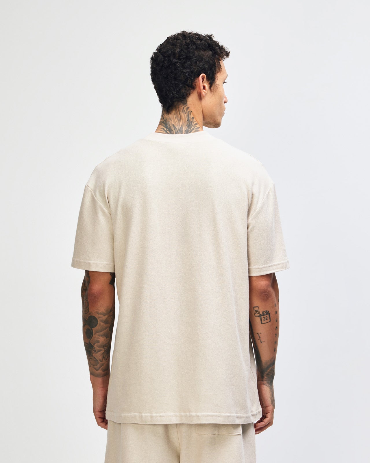 Male model wearing a Pique Unisex Mockneck Tee (front pose) -bone