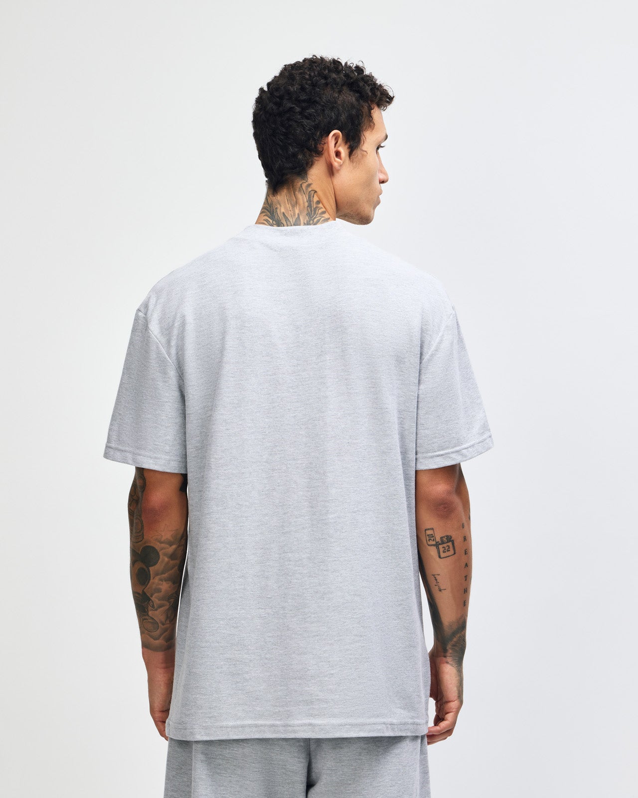 Male model wearing a Pique Unisex Mockneck Tee (front pose) -heather grey