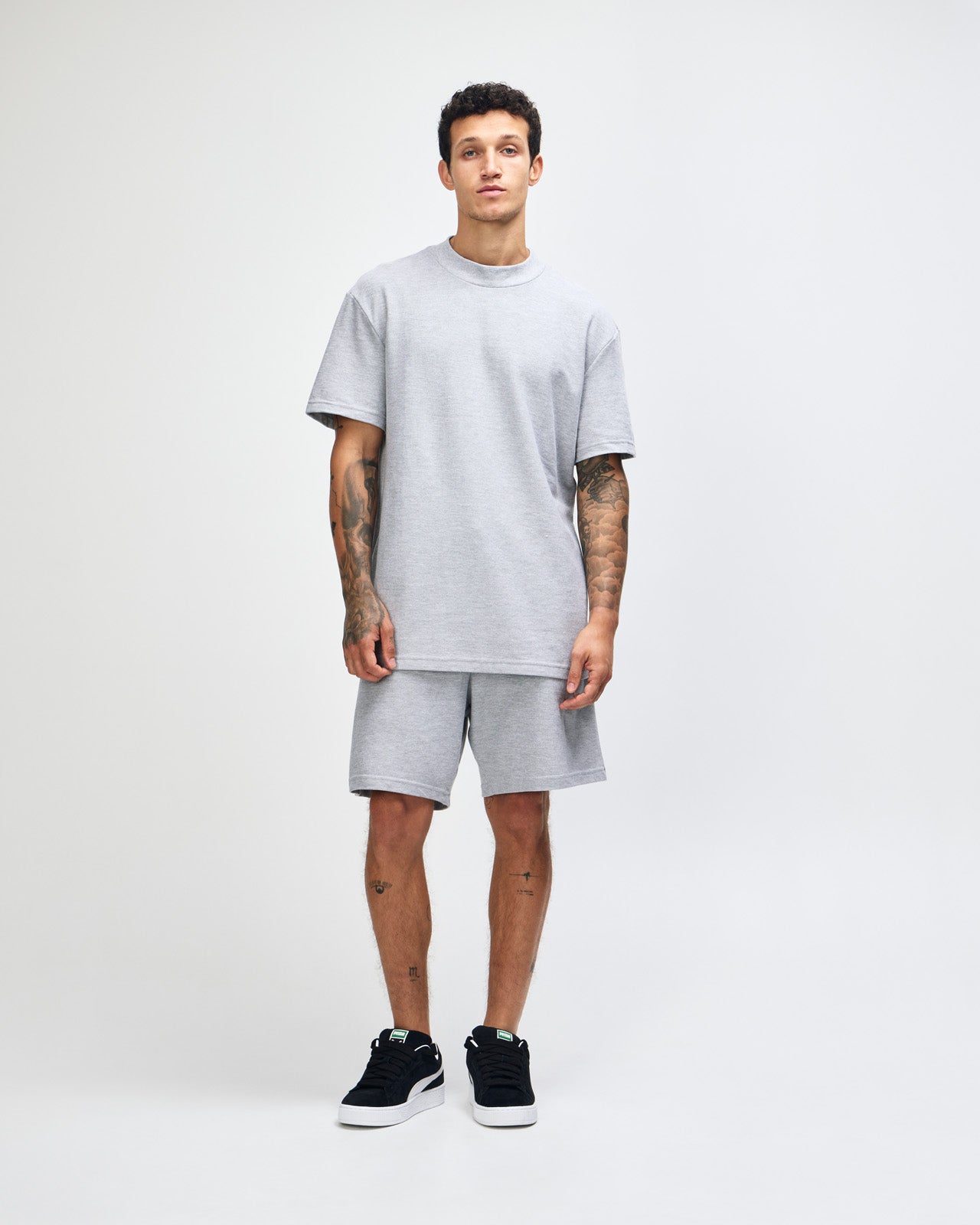Male model wearing a Pique Unisex Mockneck Tee (front pose) -heather grey