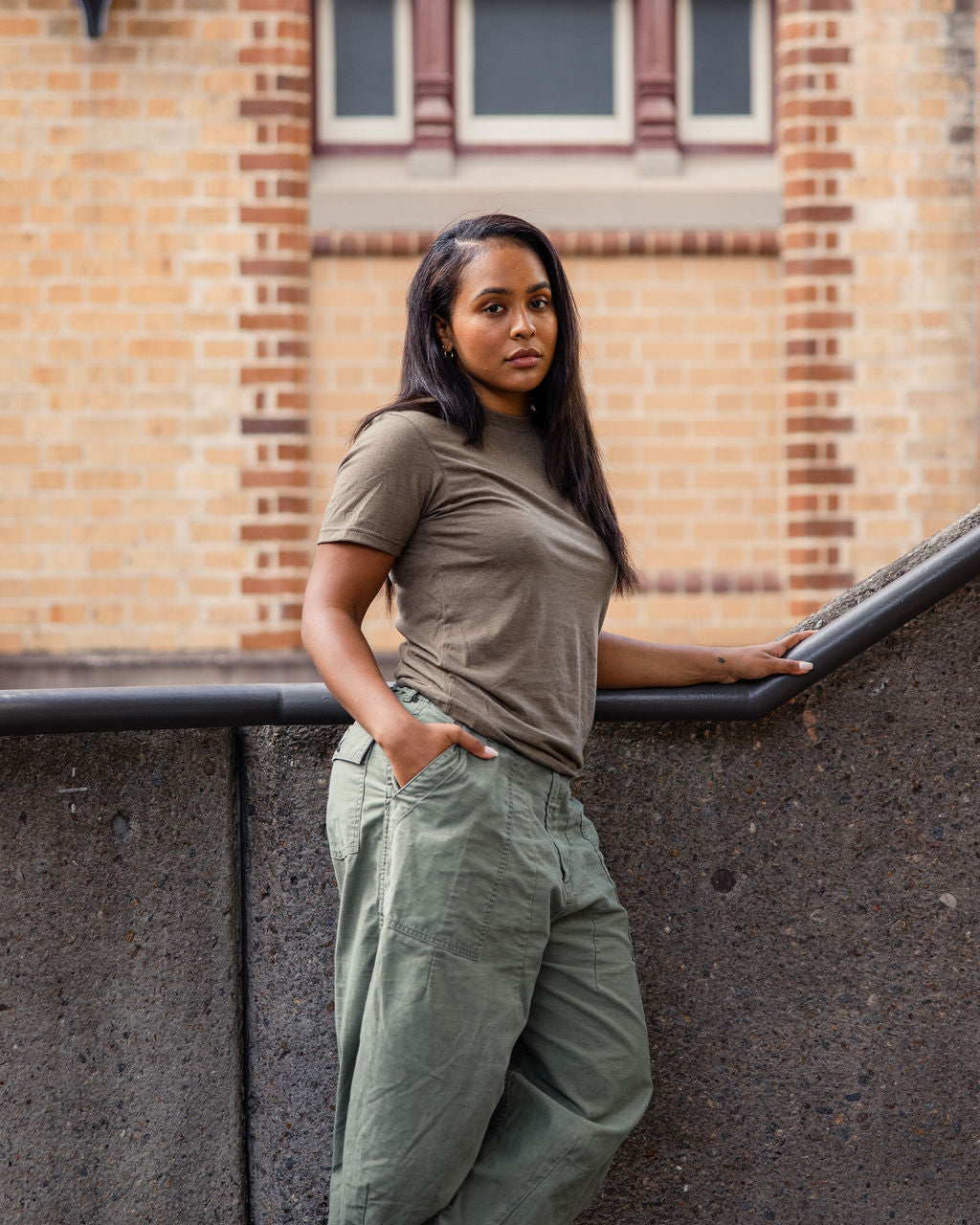 Female model wearing heather army colour CVC Unisex Short Sleeve Crew Neck Tee (back pose) - heather army