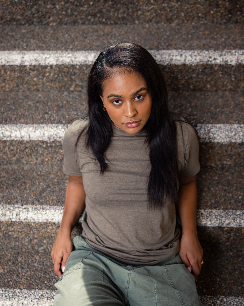 Female model wearing heather army colour CVC Unisex Short Sleeve Crew Neck Tee (back pose) - heather army