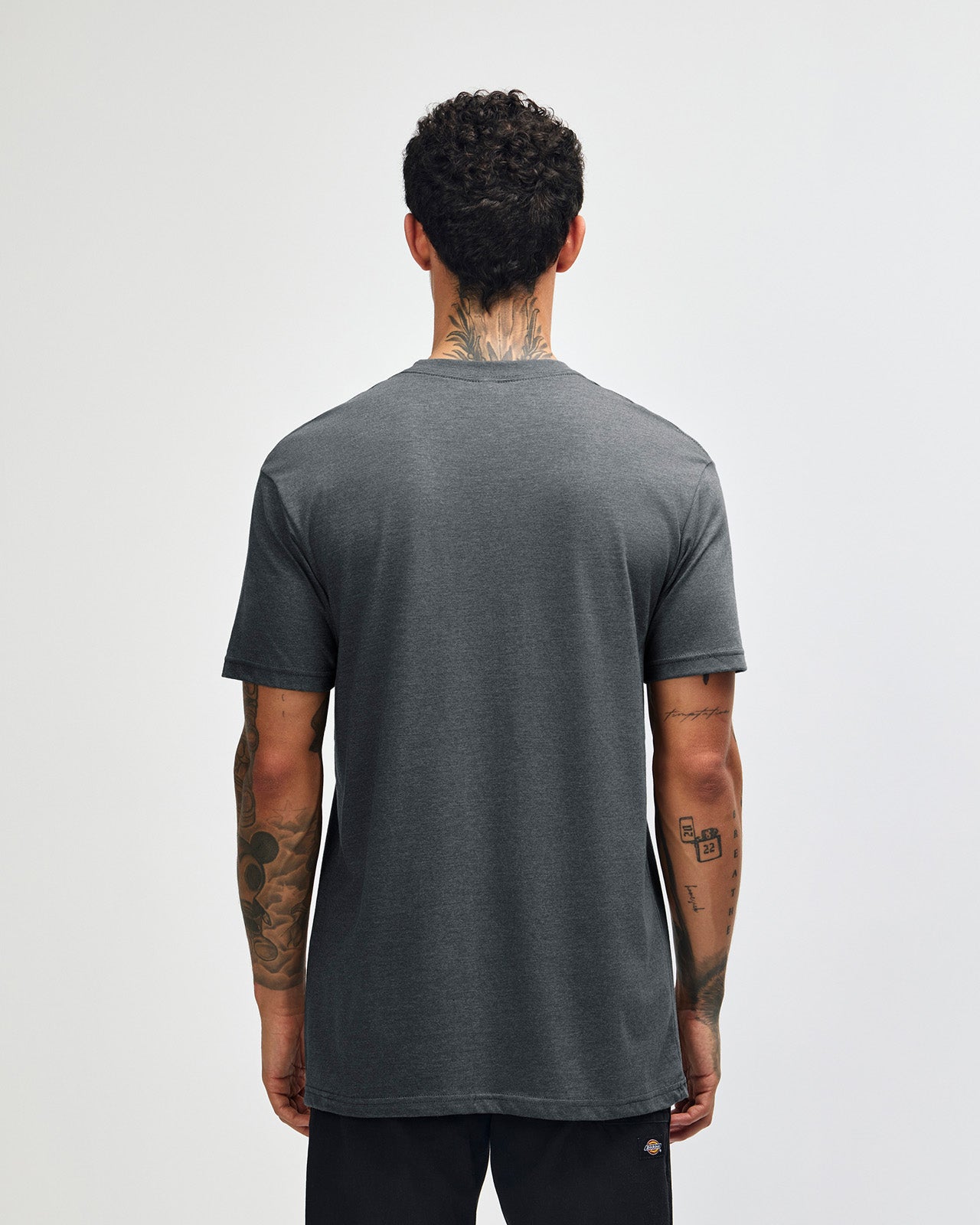 Male model wearing heather asphalt colour CVC Unisex Short Sleeve Crew Neck Tee (back pose) -heather asphalt