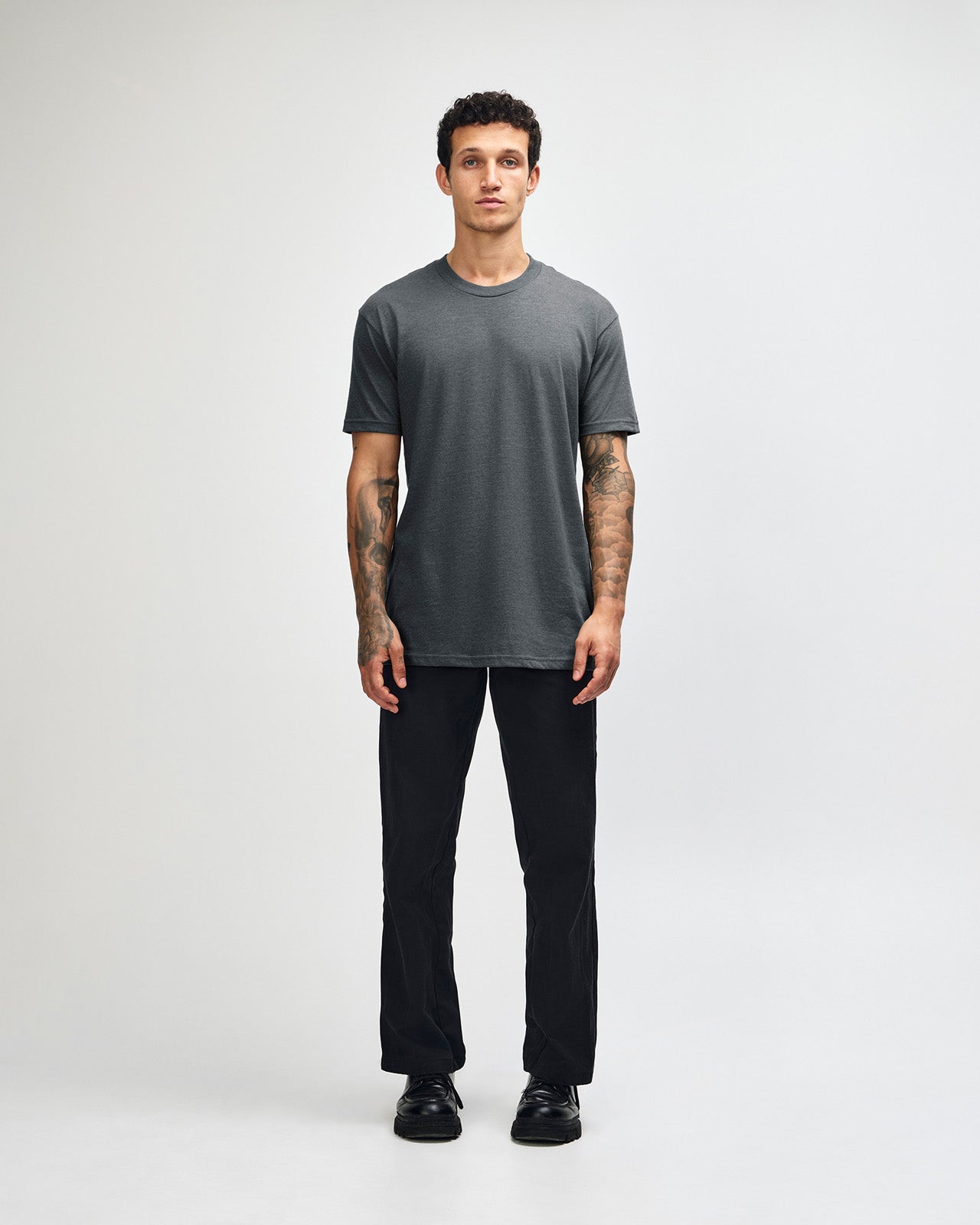 Male model wearing heather asphalt colour CVC Unisex Short Sleeve Crew Neck Tee (front pose) -heather asphalt