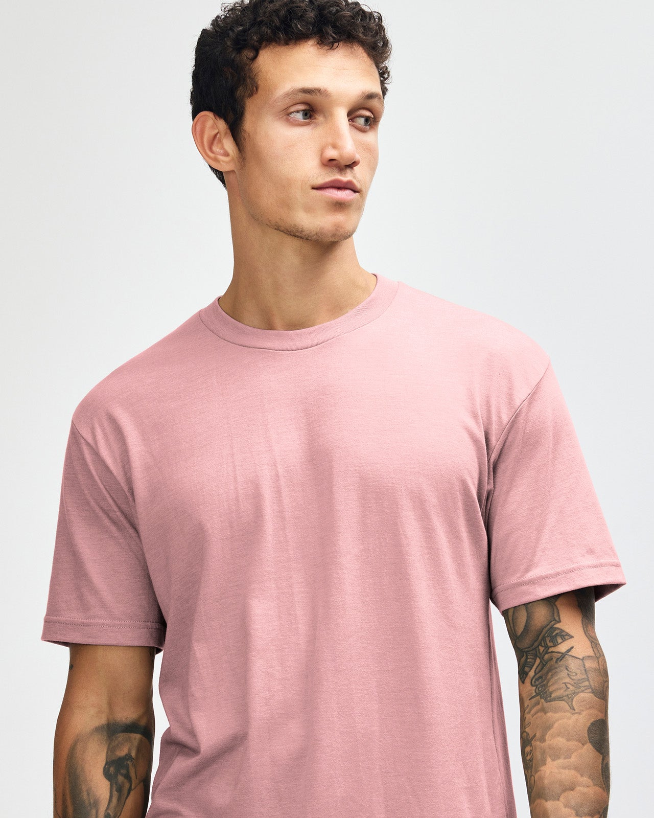 Male model wearing heather blush colour CVC Unisex Short Sleeve Crew Neck Tee (front pose) -heather blush