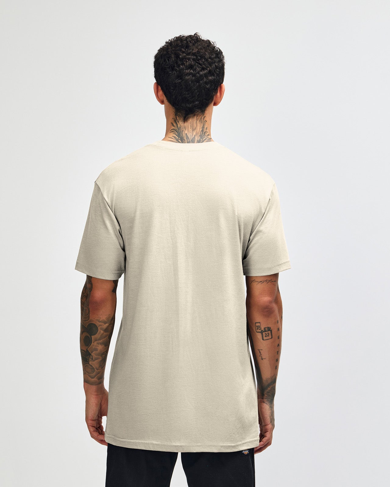 Male model wearing heather bone colour CVC Unisex Short Sleeve Crew Neck Tee (back pose) -heather bone