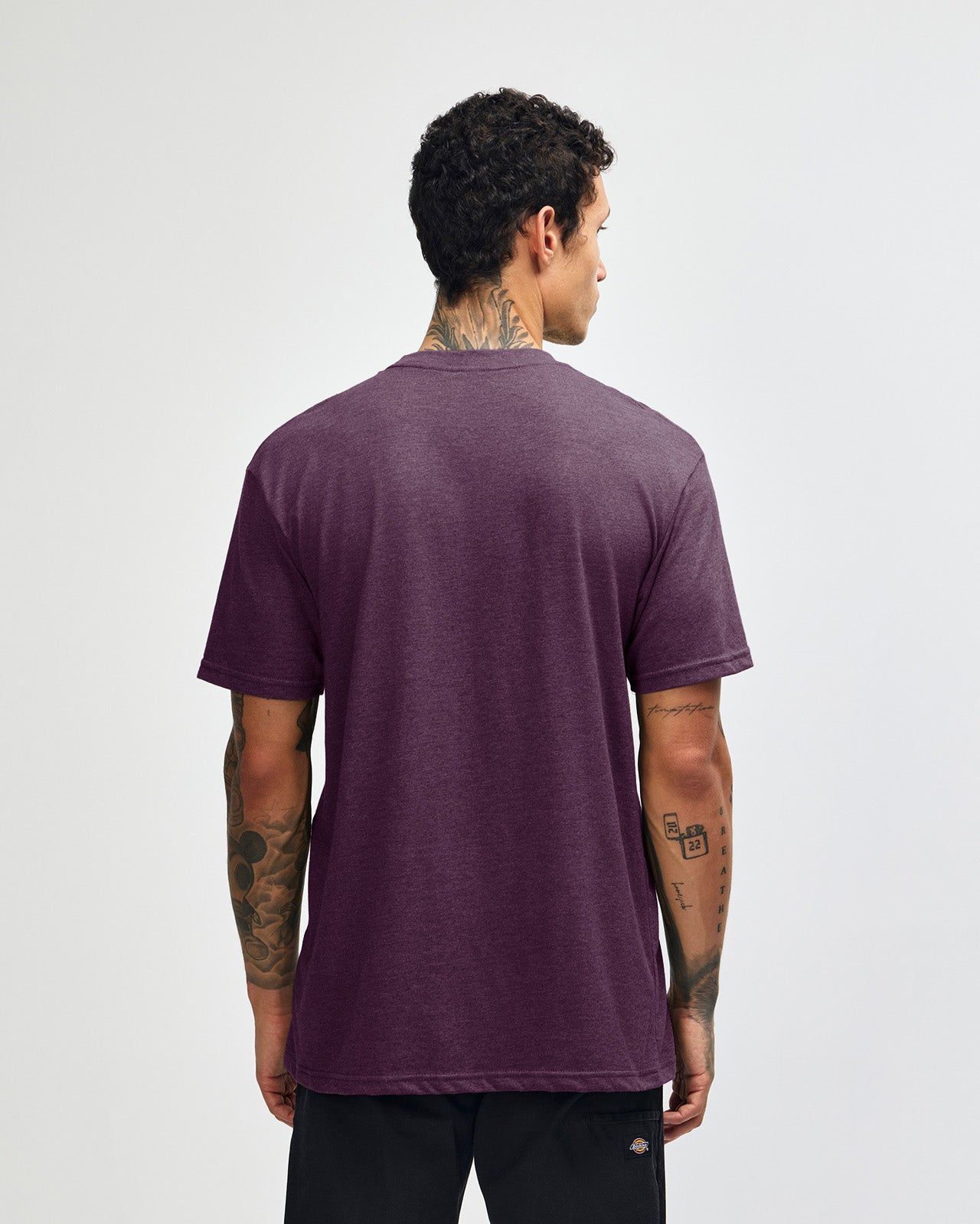 Male model wearing heather eggplant colour CVC Unisex Short Sleeve Crew Neck Tee (back pose) -heather eggplant