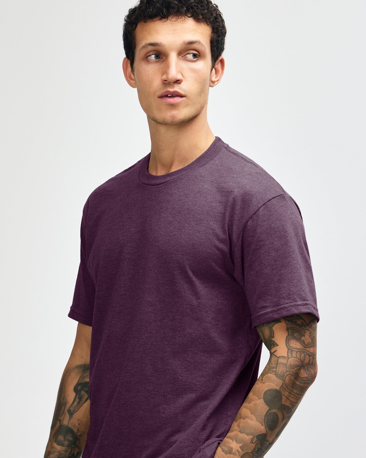 Male model wearing heather eggplant colour CVC Unisex Short Sleeve Crew Neck Tee (front pose) -heather eggplant