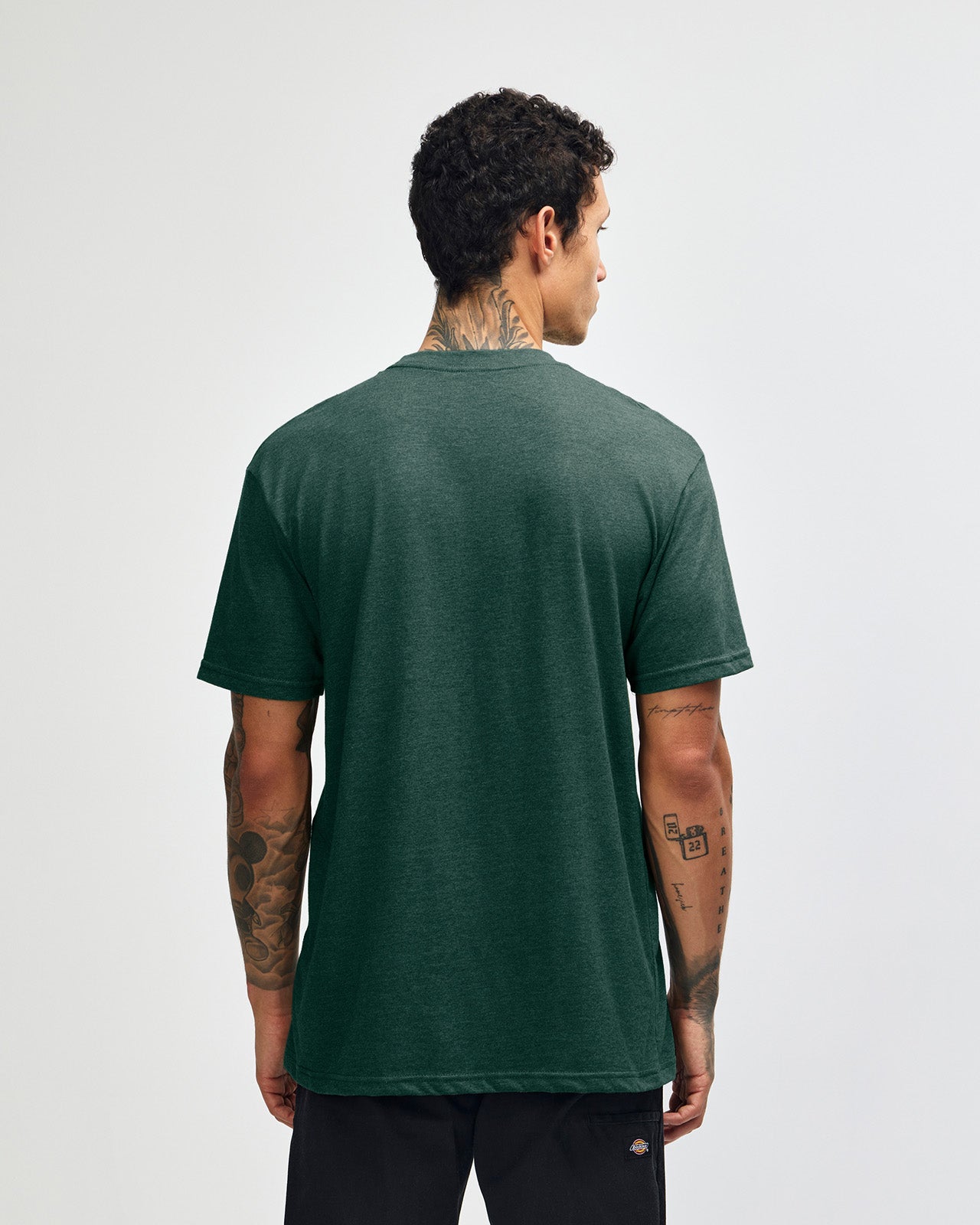 Male model wearing heather forest colour CVC Unisex Short Sleeve Crew Neck Tee (back pose) -heather forest