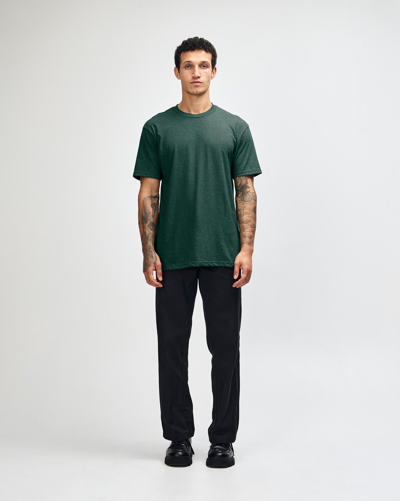 Male model wearing heather forest colour CVC Unisex Short Sleeve Crew Neck Tee (front pose) -heather forest