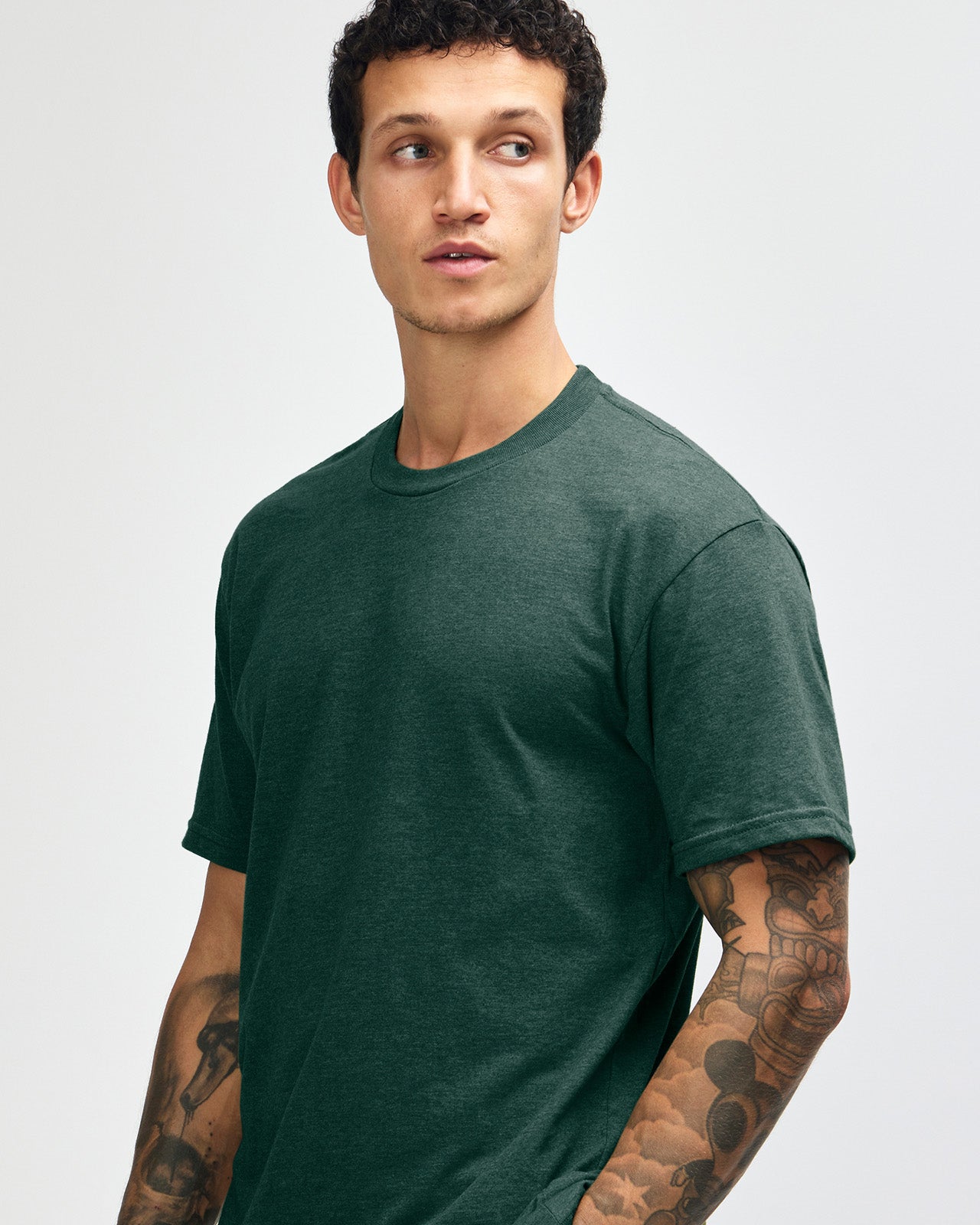 Male model wearing heather forest colour CVC Unisex Short Sleeve Crew Neck Tee (front pose) -heather forest