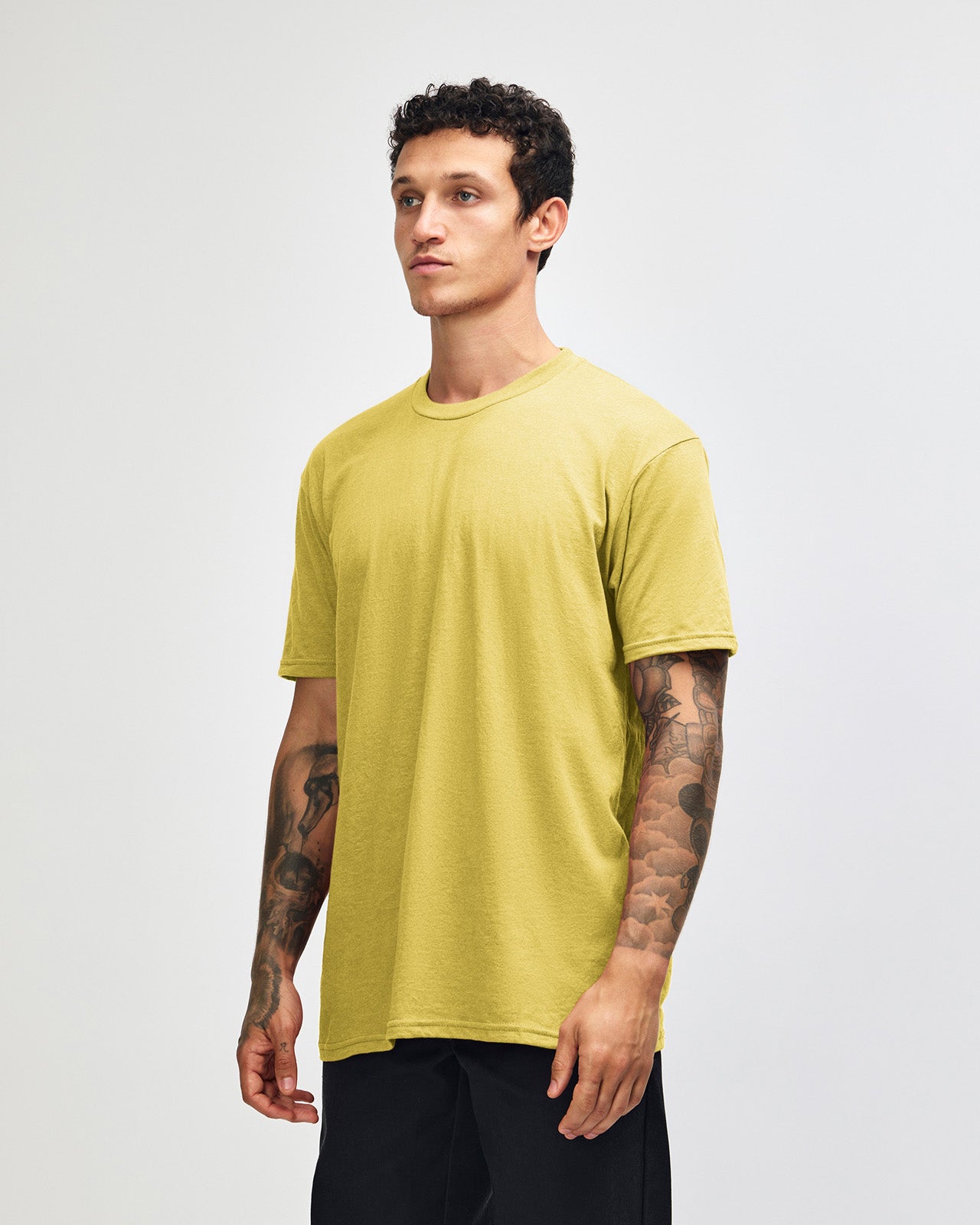 Male model wearing heather pannacotta colour CVC Unisex Short Sleeve Crew Neck Tee (size pose) -heather pannacotta
