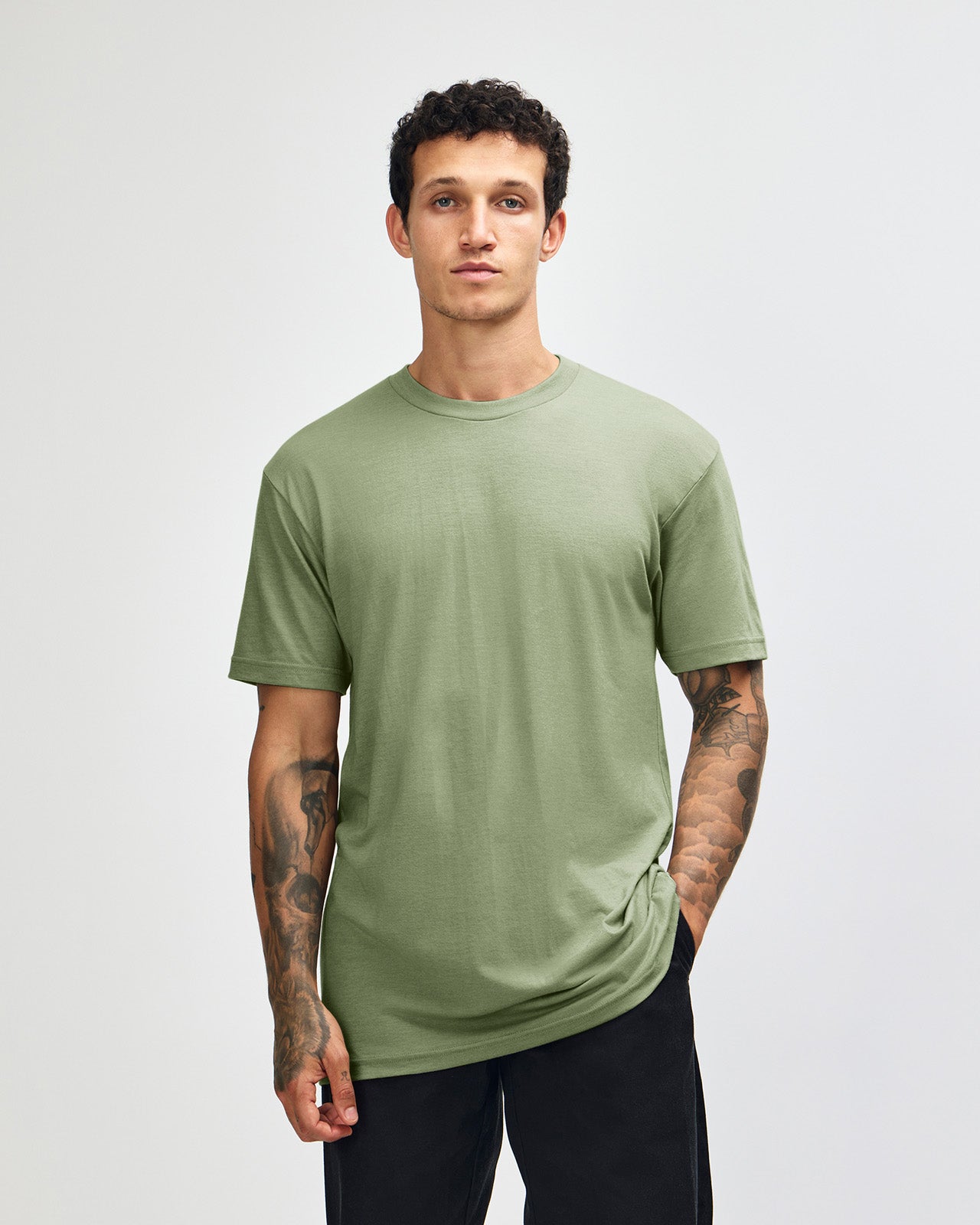 Male model wearing heather sage colour CVC Unisex Short Sleeve Crew Neck Tee (front pose) -heather sage
