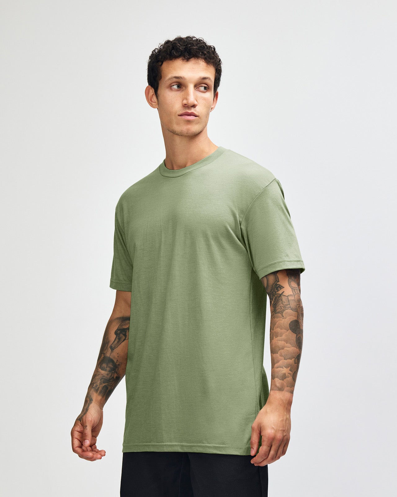 Male model wearing heather sage colour CVC Unisex Short Sleeve Crew Neck Tee (front pose) -heather sage