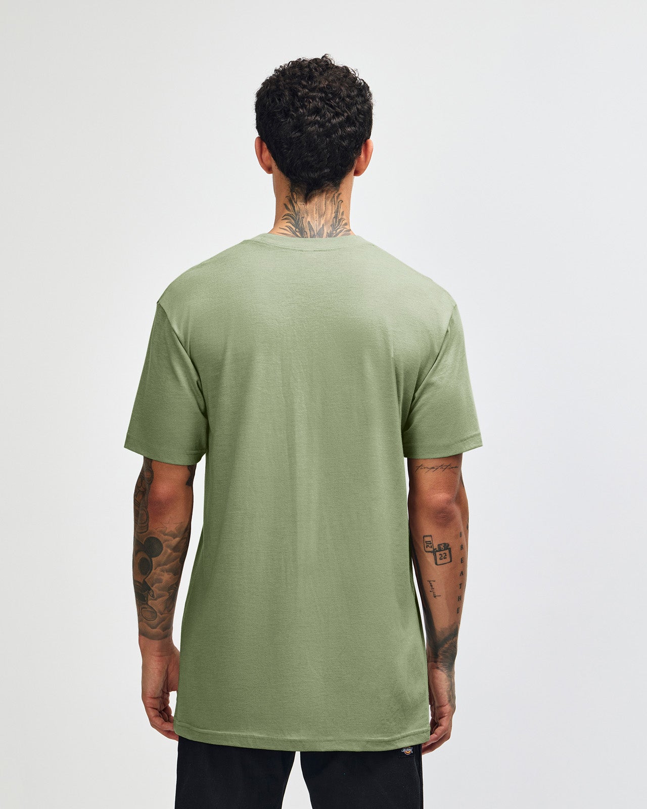 Male model wearing heather sage colour CVC Unisex Short Sleeve Crew Neck Tee (back pose) -heather sage