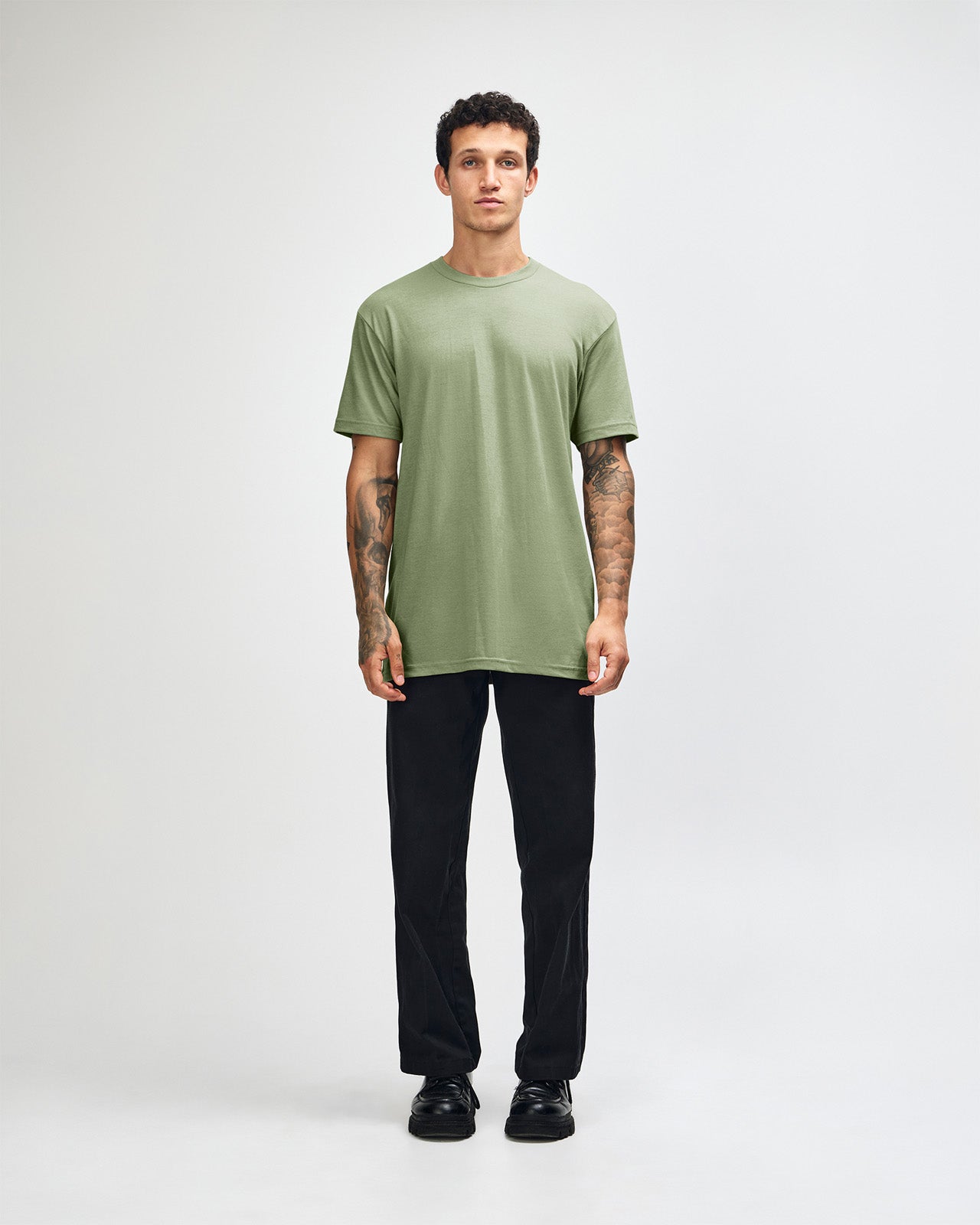 Male model wearing heather sage colour CVC Unisex Short Sleeve Crew Neck Tee (front pose) -heather sage