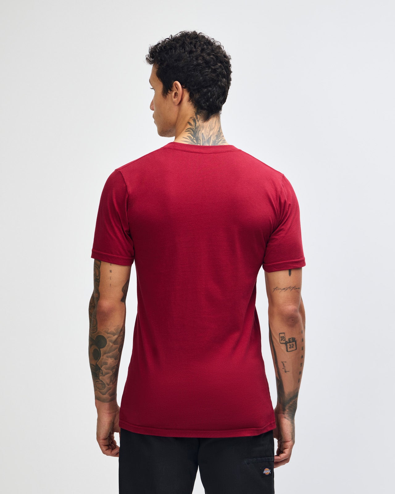 Male mode wearing cranberry colour American Apparel Unisex Short Sleeve Crew Neck Tee (back pose) -cranberry