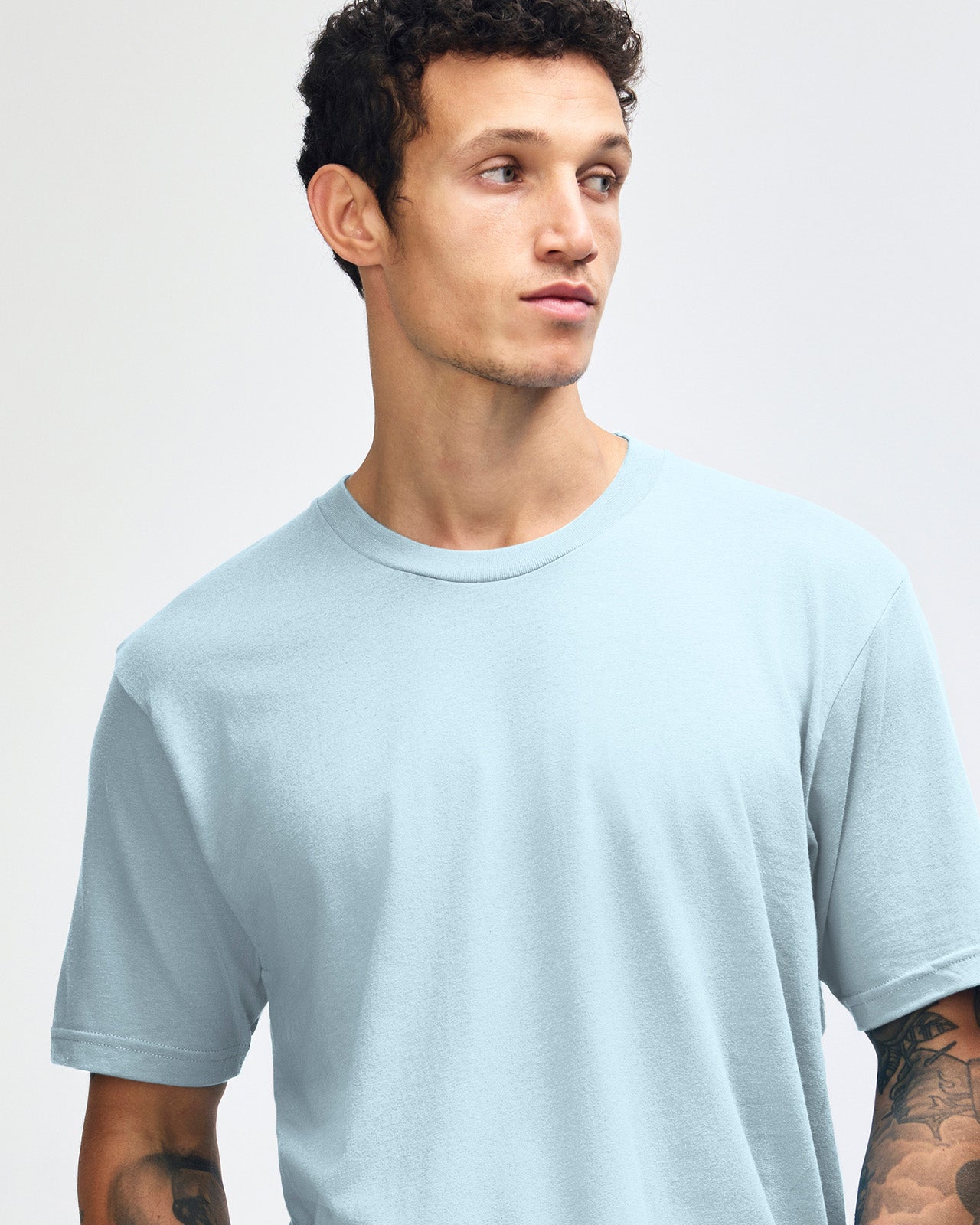 Male model wearing American Apparel Powder Blue Colour Fine Jersey Unisex Short Sleeve Crew Neck Tee (front pose) -powder blue