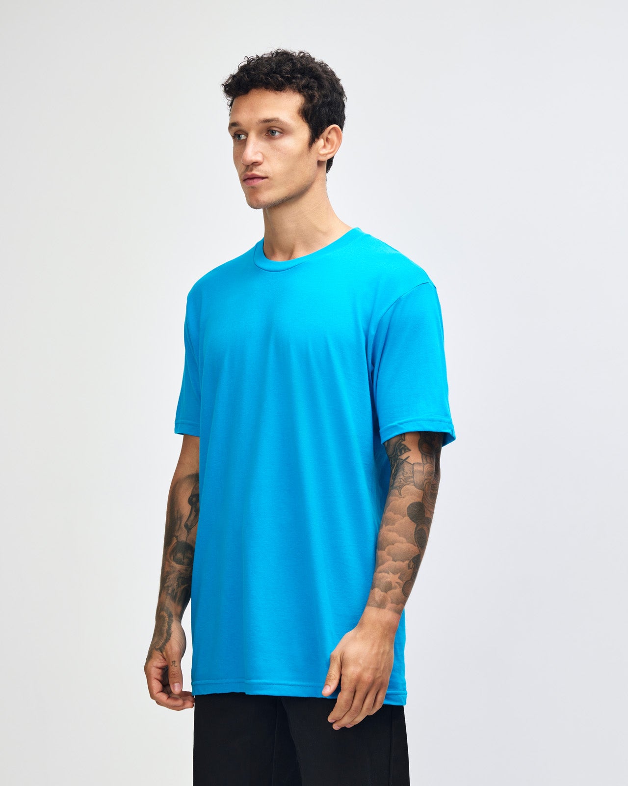 Male model wearing American Apparel Powder teal Colour Fine Jersey Unisex Short Sleeve Crew Neck Tee (front pose) -teal
