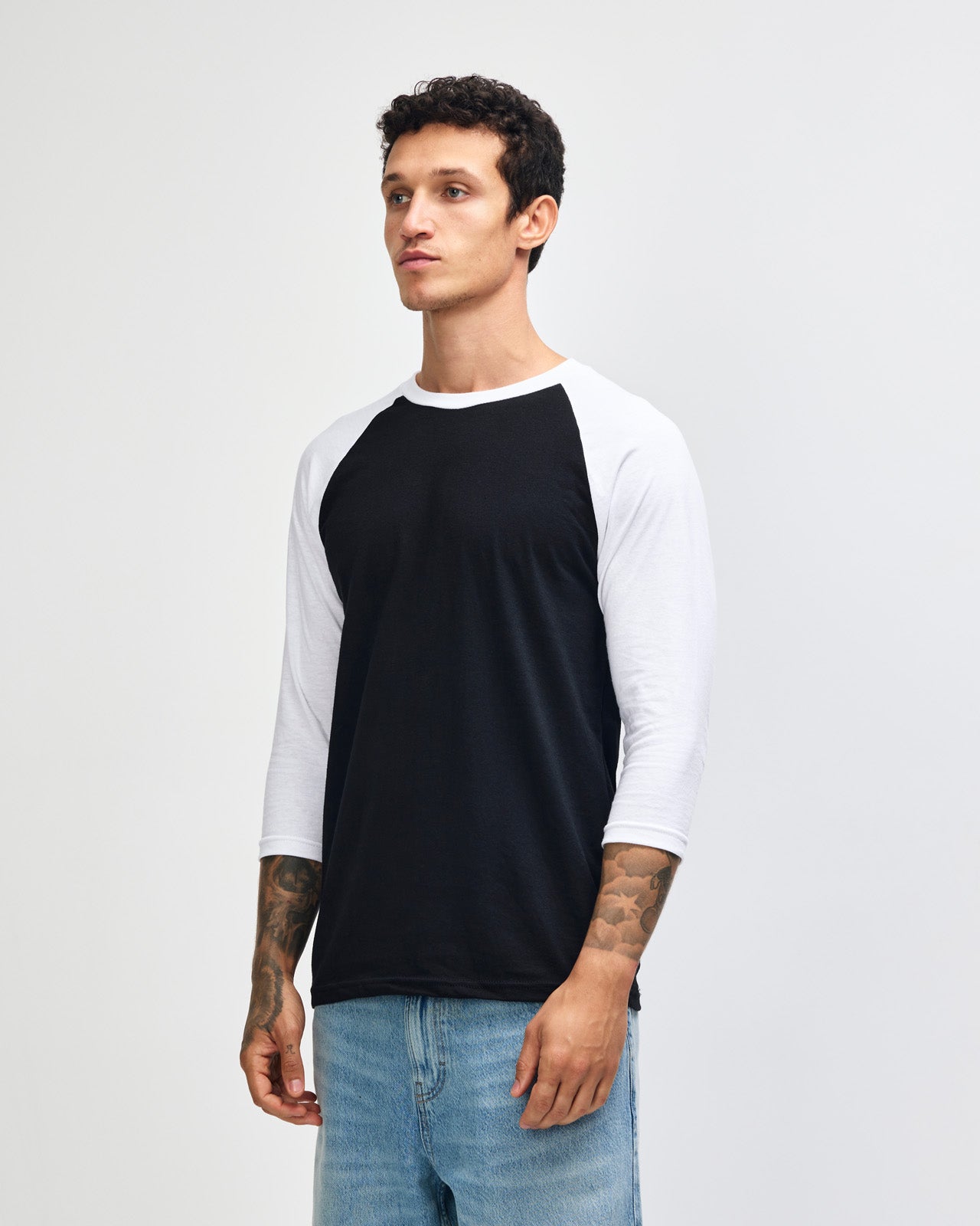 Male model wearing American Apparel CVC unisex raglan Tee (front pose) -black 