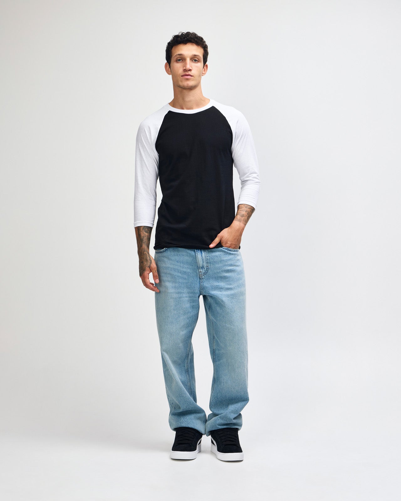 Male model wearing American Apparel CVC unisex raglan Tee (front pose) -black 
