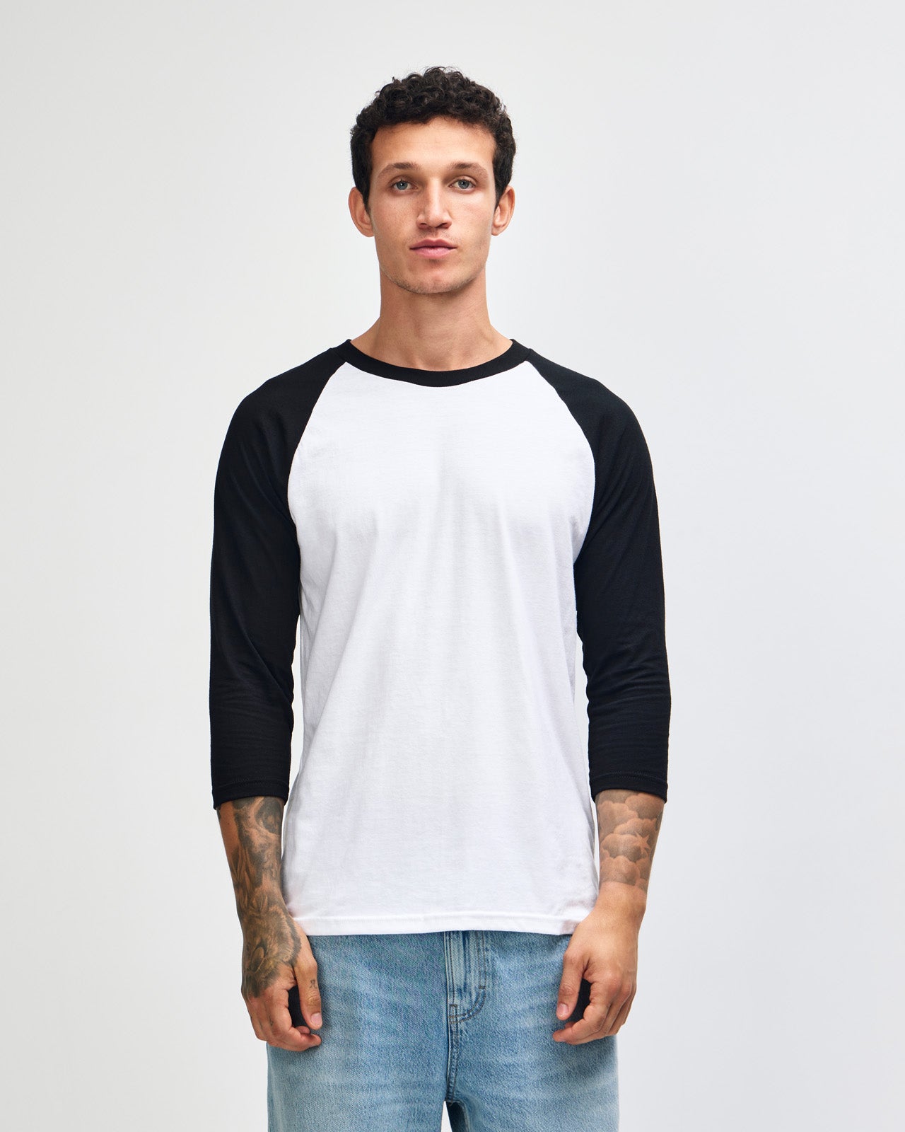 Male model wearing American Apparel CVC unisex raglan Tee (front pose) -white