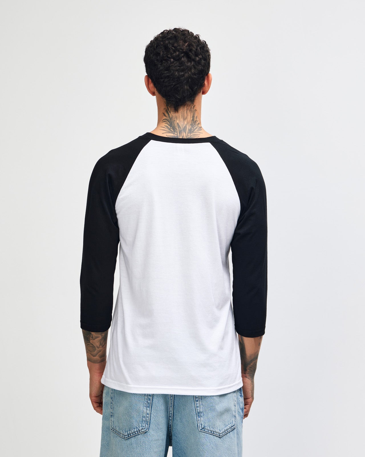 Male model wearing American Apparel CVC unisex raglan Tee (front pose) -white
