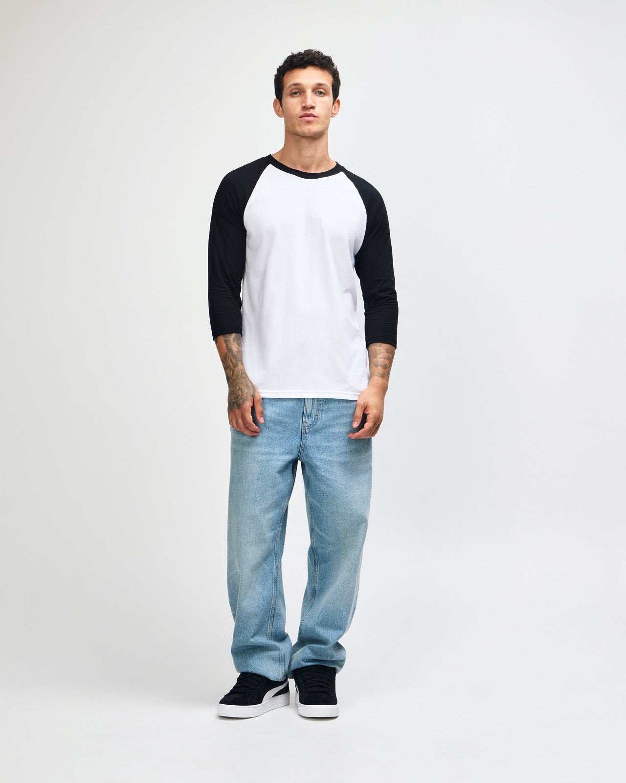 Male model wearing American Apparel CVC unisex raglan Tee (front pose) -white