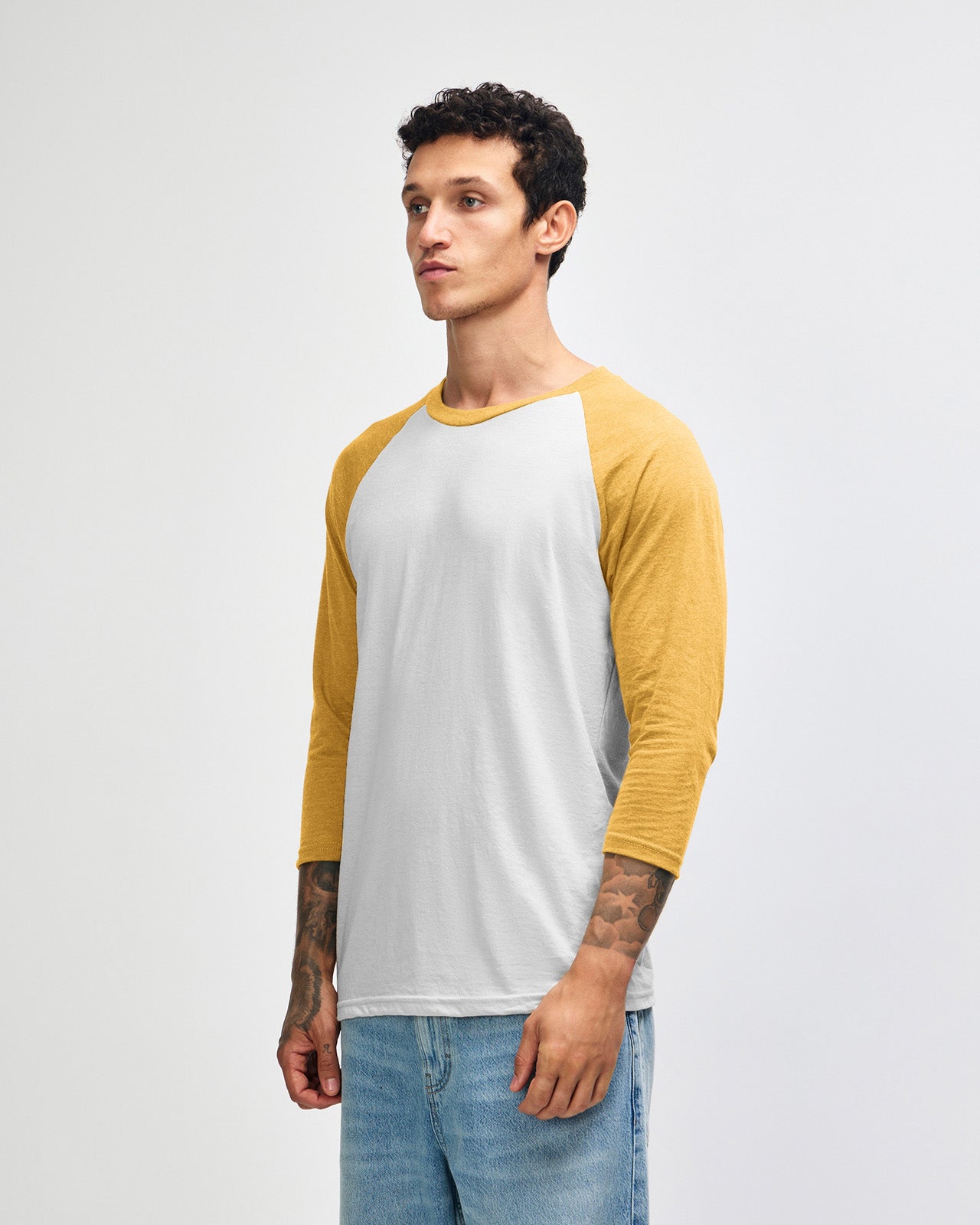 Male model wearing American Apparel CVC unisex raglan Tee (front pose) - heather mustard
