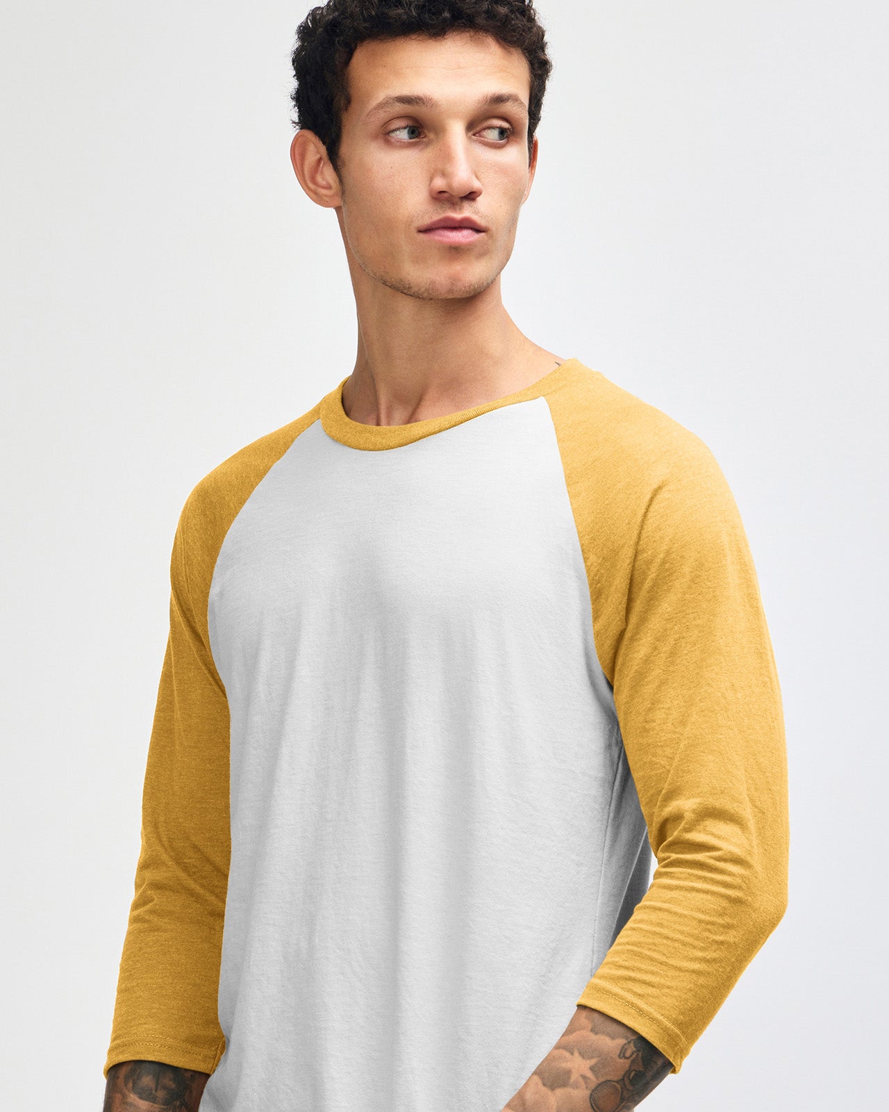 Male model wearing American Apparel CVC unisex raglan Tee (front pose) - heather mustard