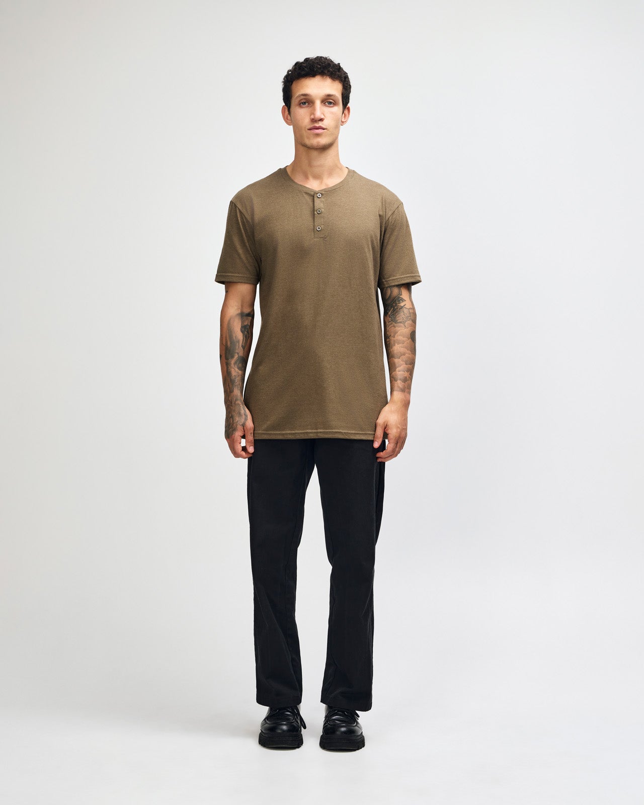 Male model wearing heather army Unisex Henley Tee (front pose) -heather army