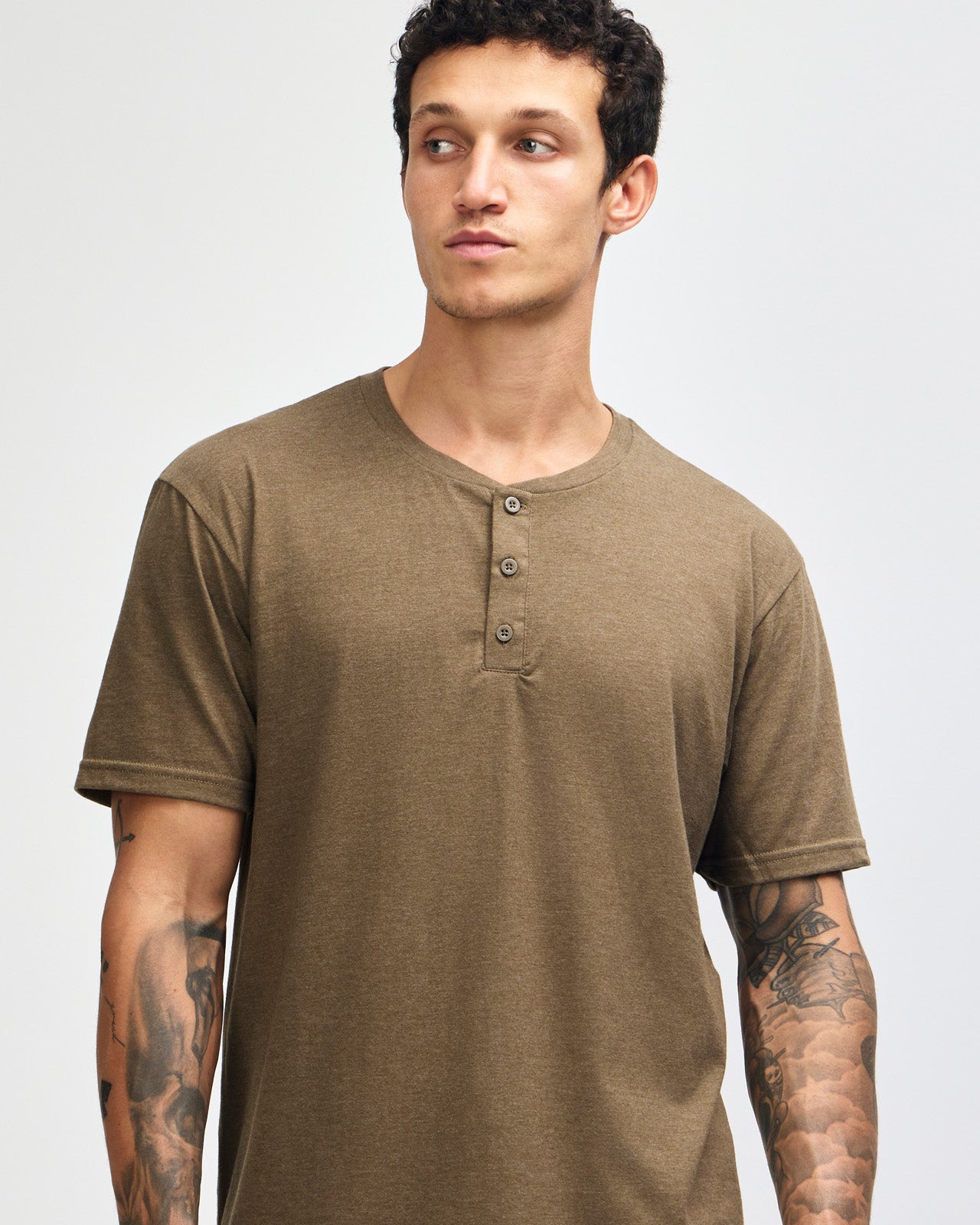 Male model wearing heather army Unisex Henley Tee (front pose) -heather army