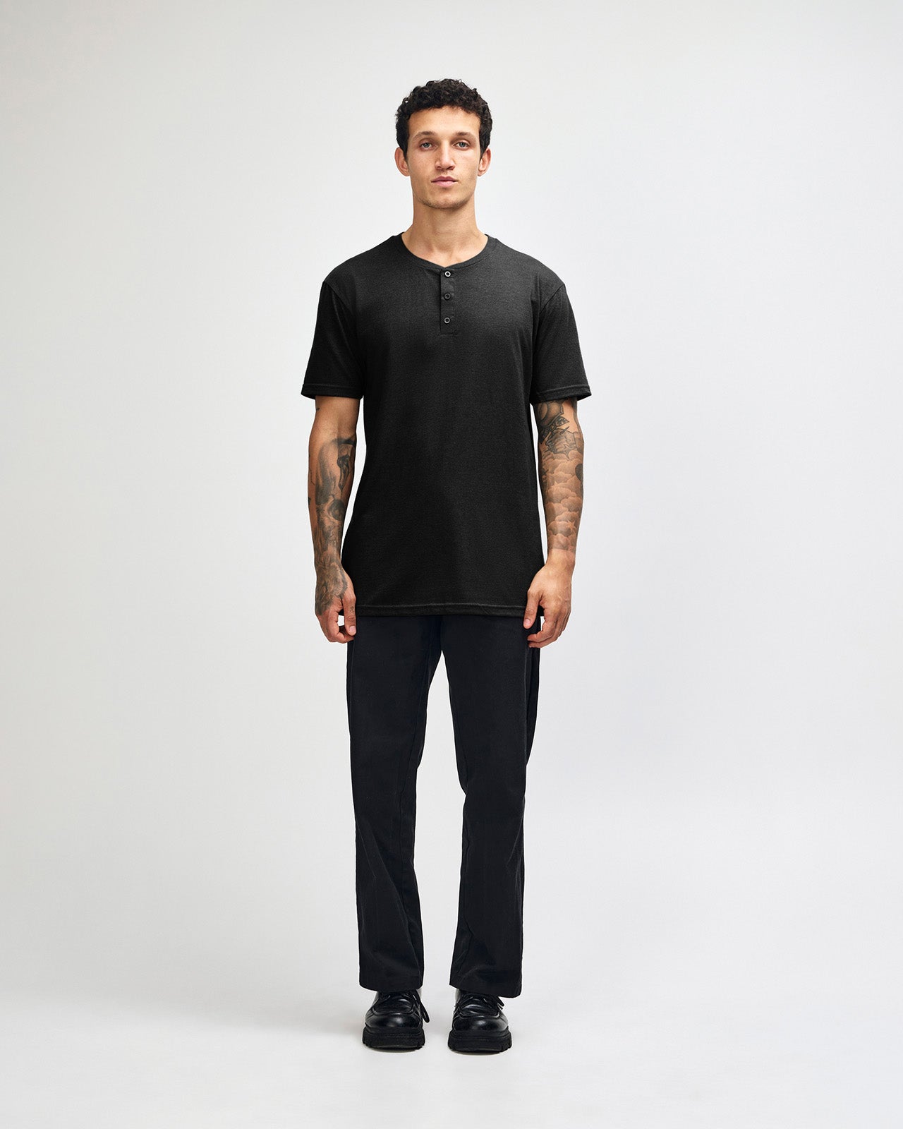 Male model wearing black colour Unisex Henley Tee (front pose) -black