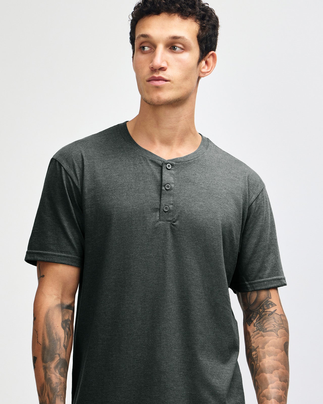Male model wearing heather charcoal Unisex Henley Tee (front pose) -heather charcoal