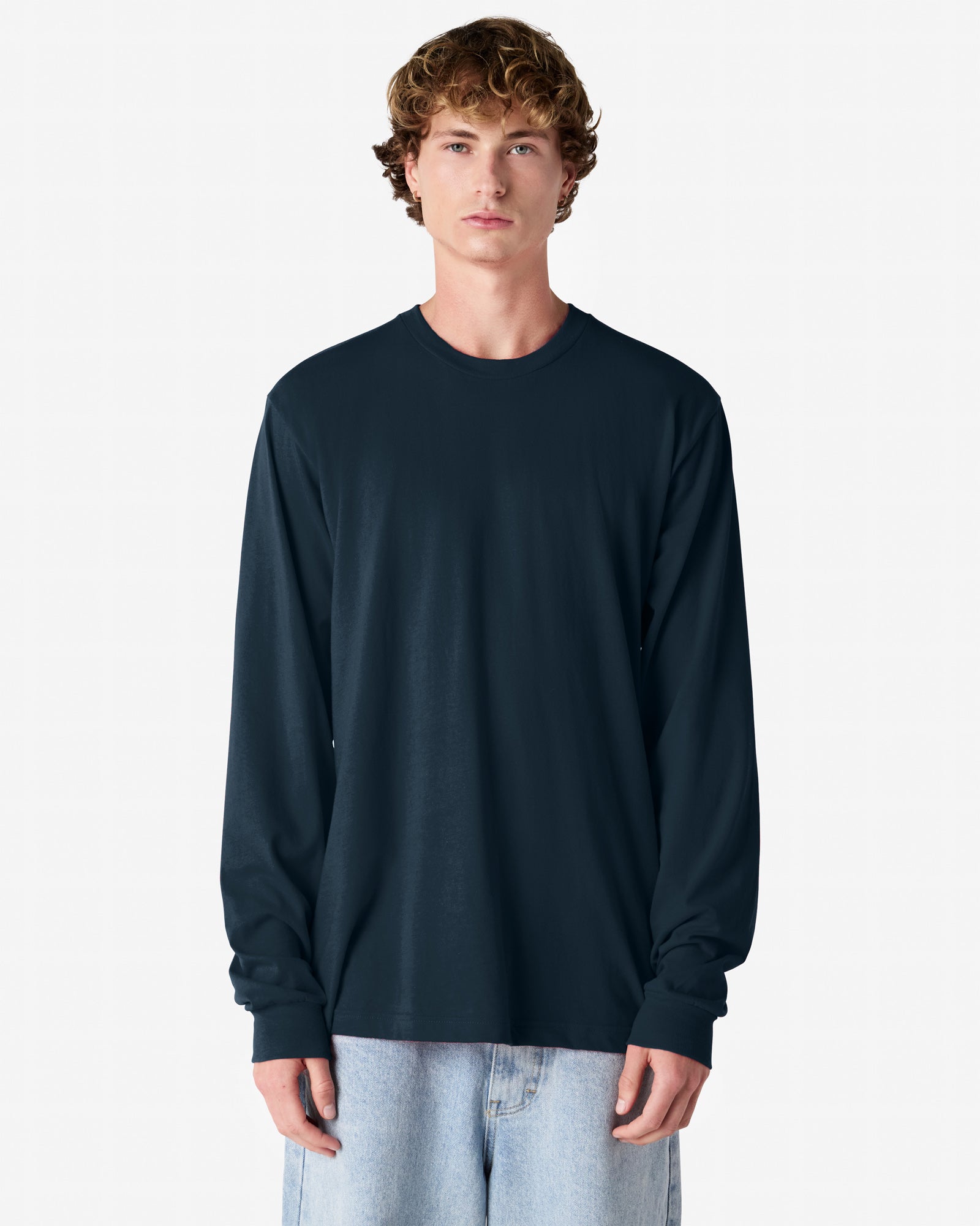 male model wearing American Apparel Navy Colour Fine Jersey Unisex Long Sleeve Crew Neck Tee (half Front pose) -Navy