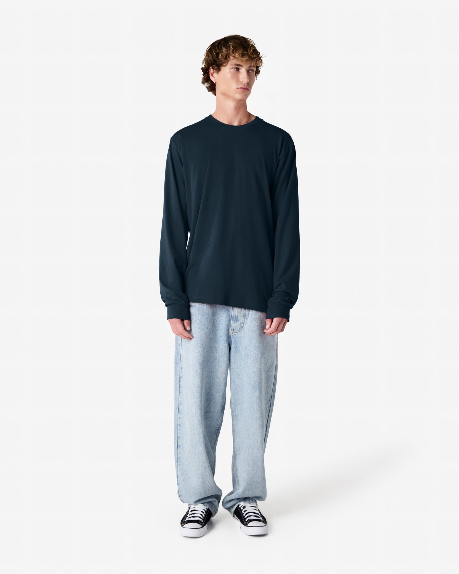 male model wearing American Apparel Navy Colour Fine Jersey Unisex Long Sleeve Crew Neck Tee (half Front pose) -Navy
