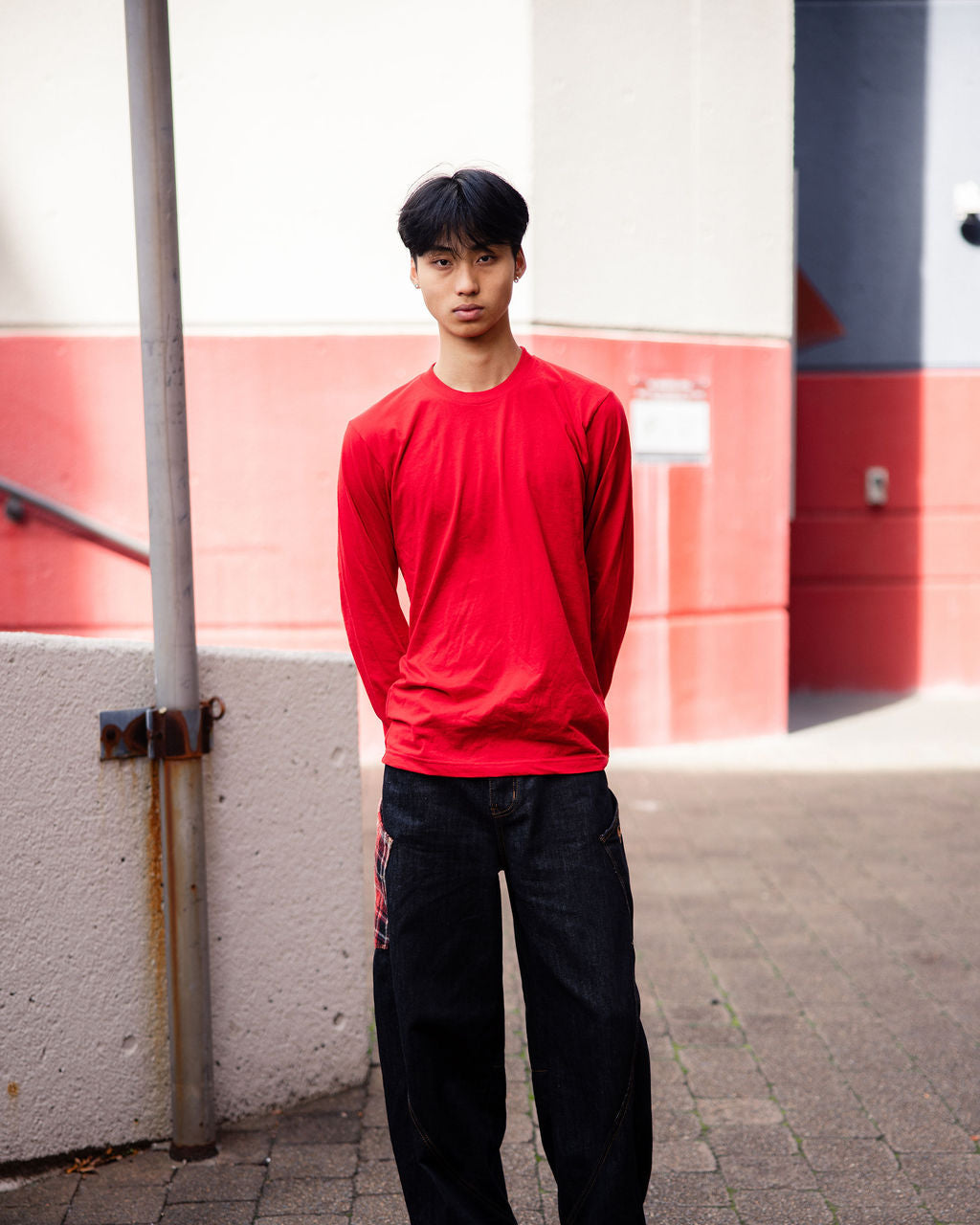 male model wearing American Apparel Red Colour Fine Jersey Unisex Long Sleeve Crew Neck Tee (Front pose) -red