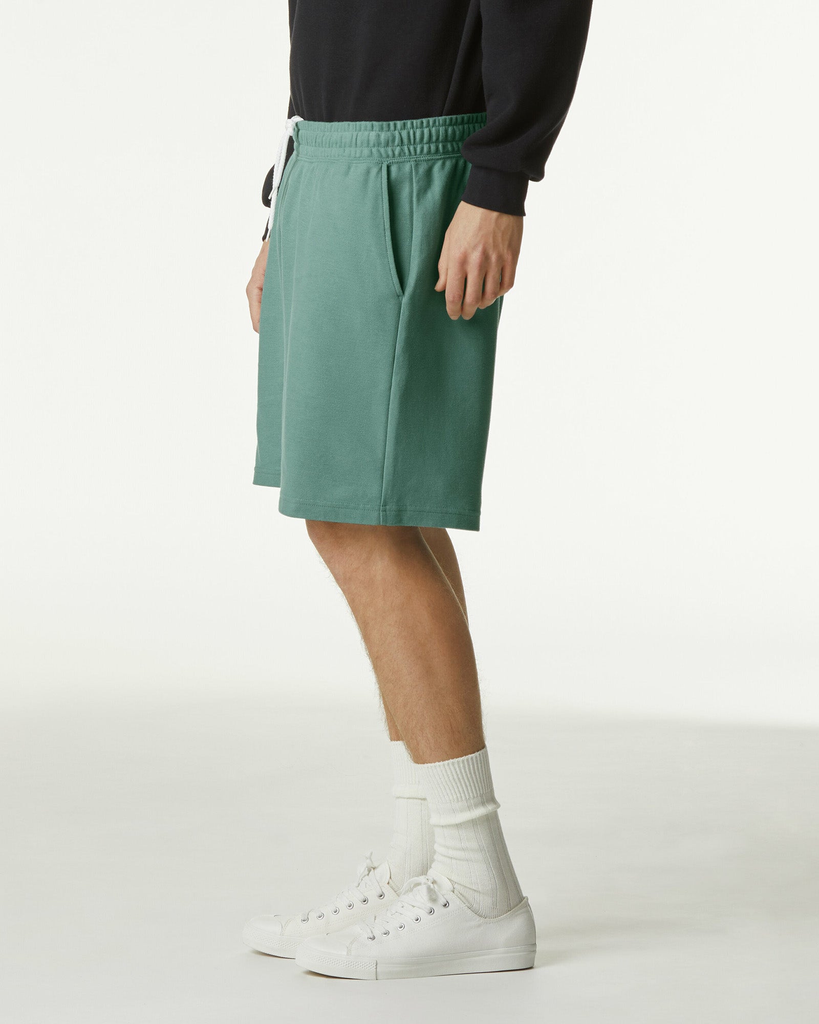 Model wearing a Pique Unisex Gym Shorts (side pose) -arctic